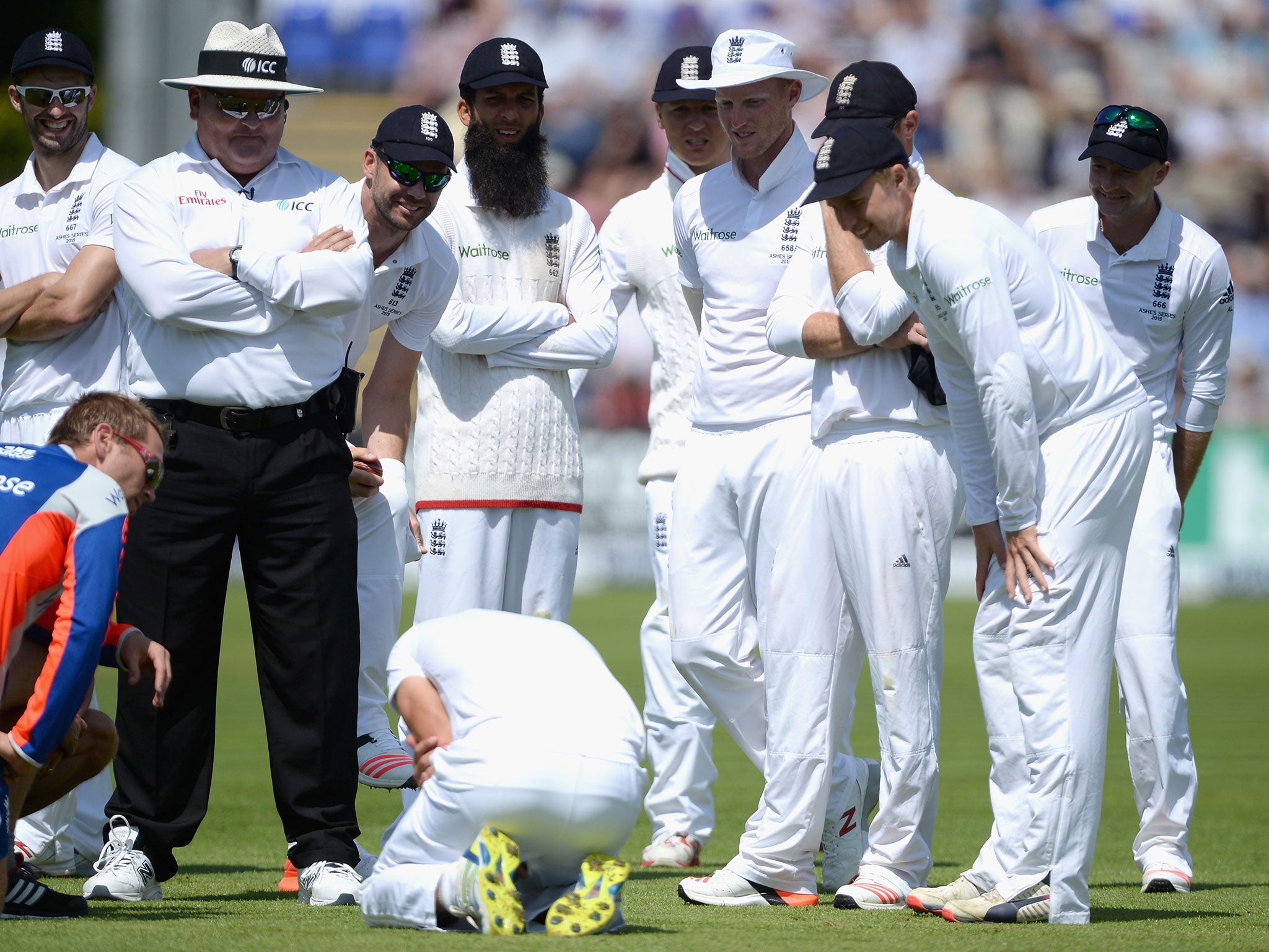 Joe Root looks on as Alastair Cook receives treatment