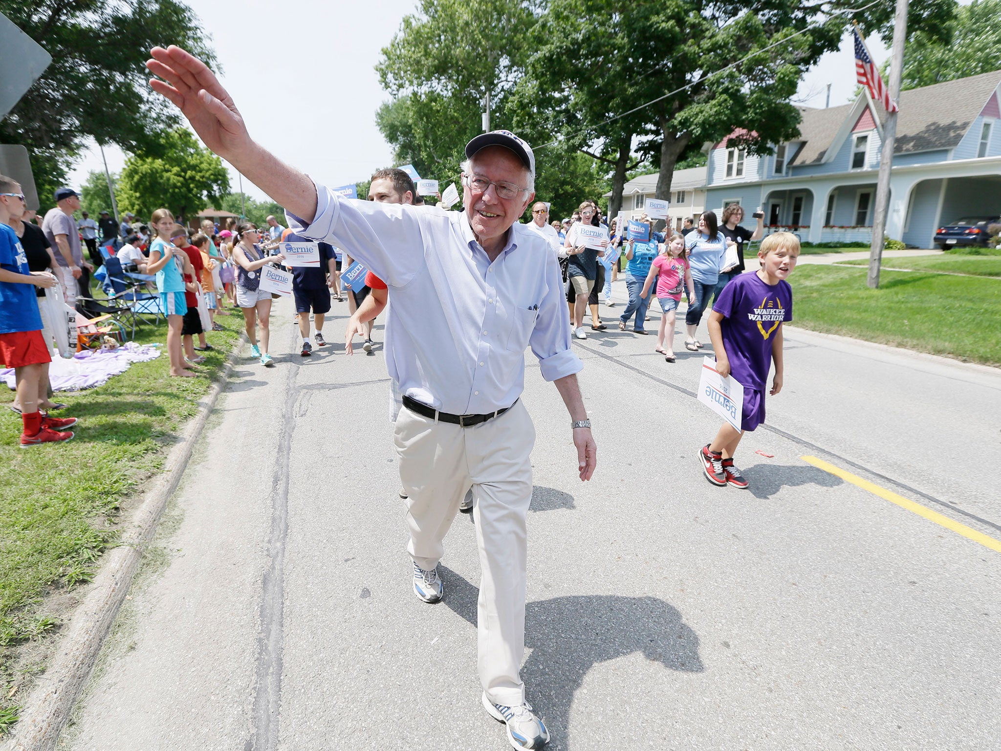 Bernie Sanders greeting residents during a Fourth of July parade in Iowa. His slogan: the United States and its government are not for sale