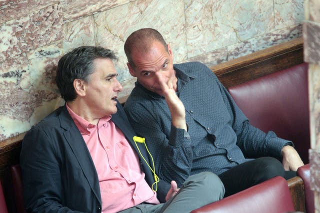 The Greek Finance Minister, Euclid Tsakalotos, left, and his predecessor, Yanis Varoufakis, talking during a plenary session of the Greek parliament
