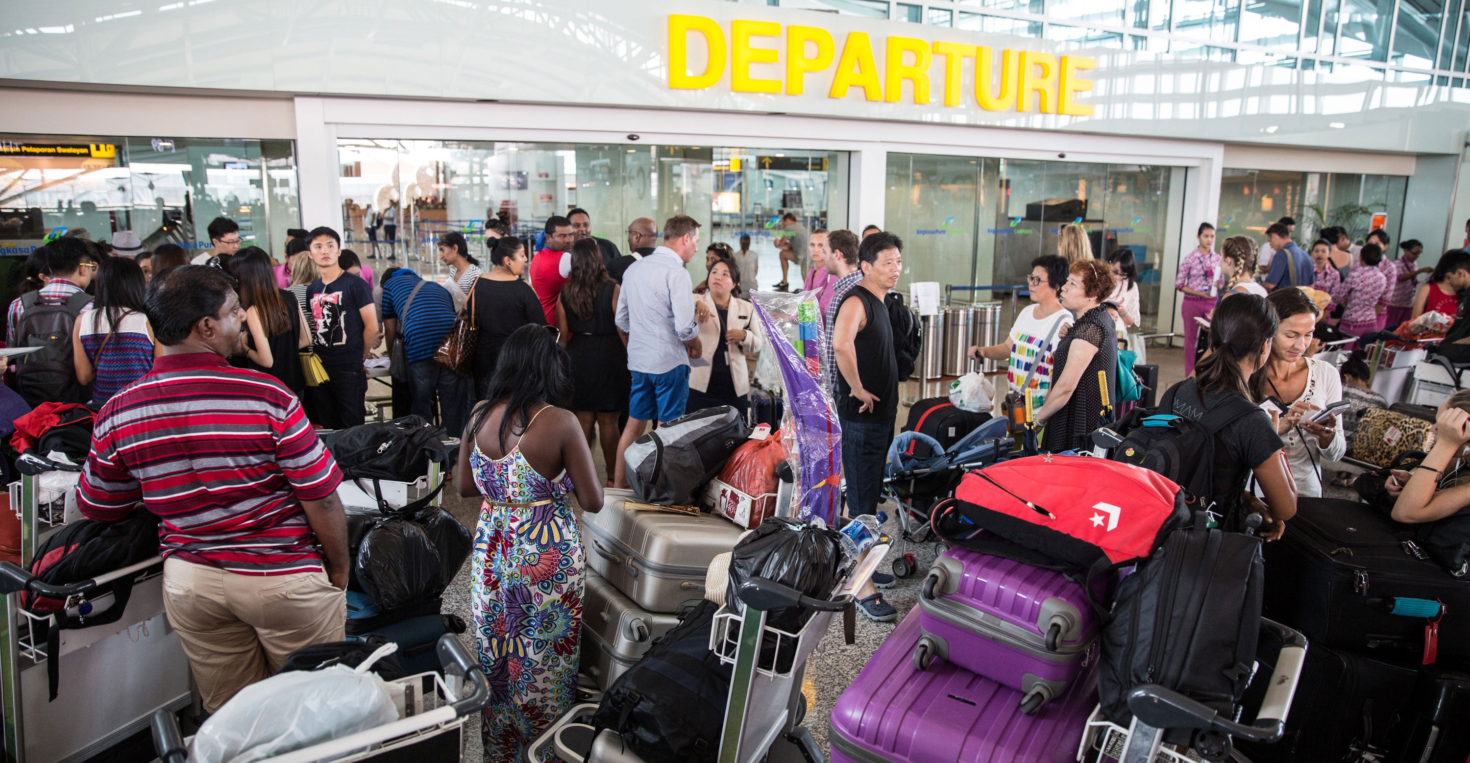 Tourist wait at Ngurah Rai International airport in Denpasar, Bali, Indonesia after over 270 flights are closed.