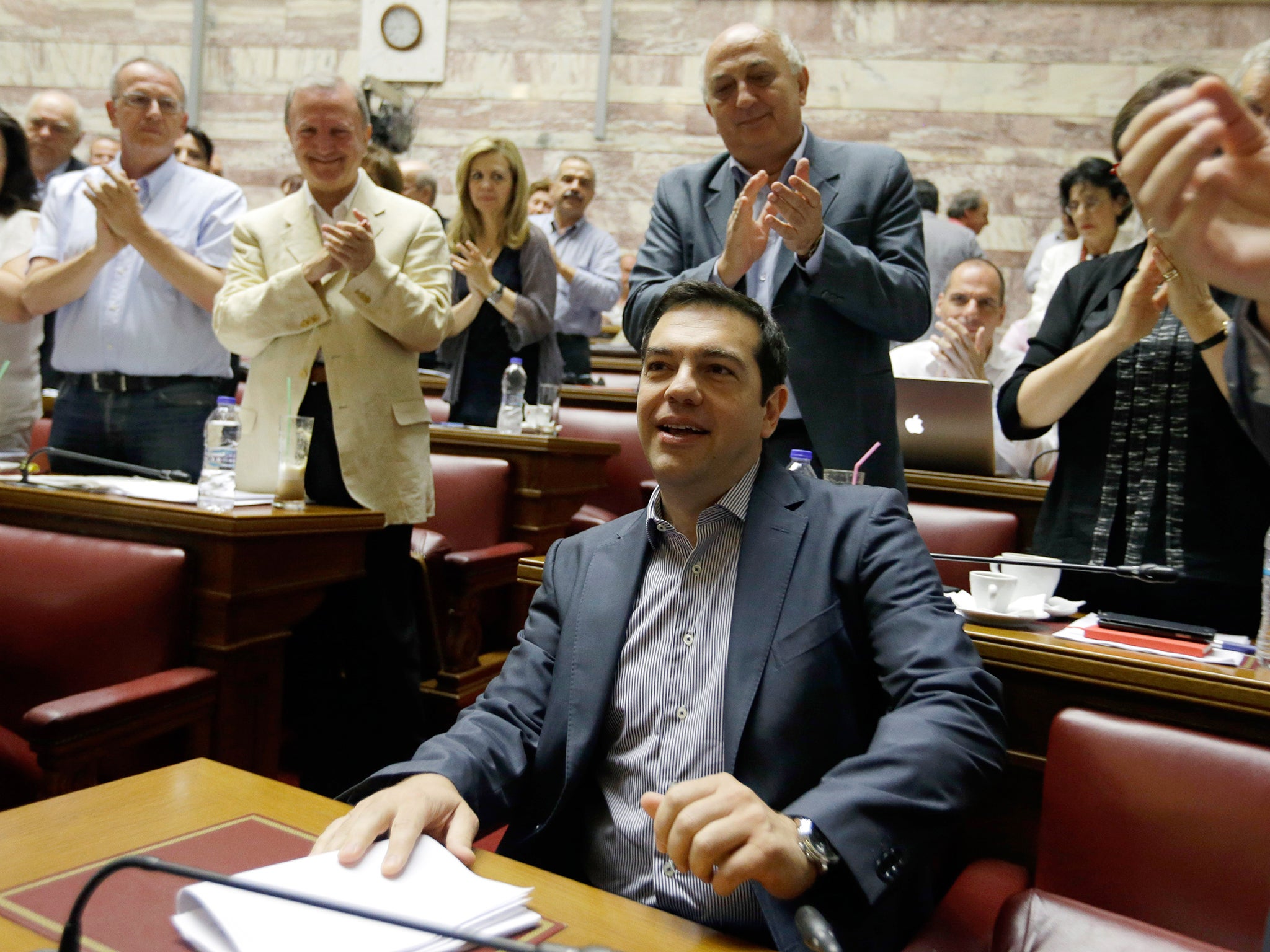 Greece's Prime Minister Alexis Tsipras a meeting as his lawmakers of Syriza party applaud him at the Greek Parliament in Athens