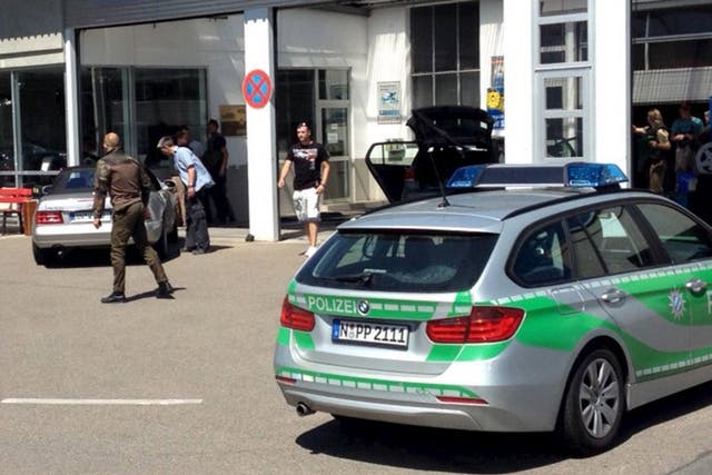 Police vehicles block a car at a petrol station in Bad Windsheim, Germany. German police said they have arrested a man suspected of shooting dead two people near Ansbach in northern Bavaria