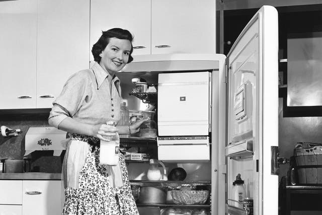 How cool: 1950s housewife beside her refrigerator