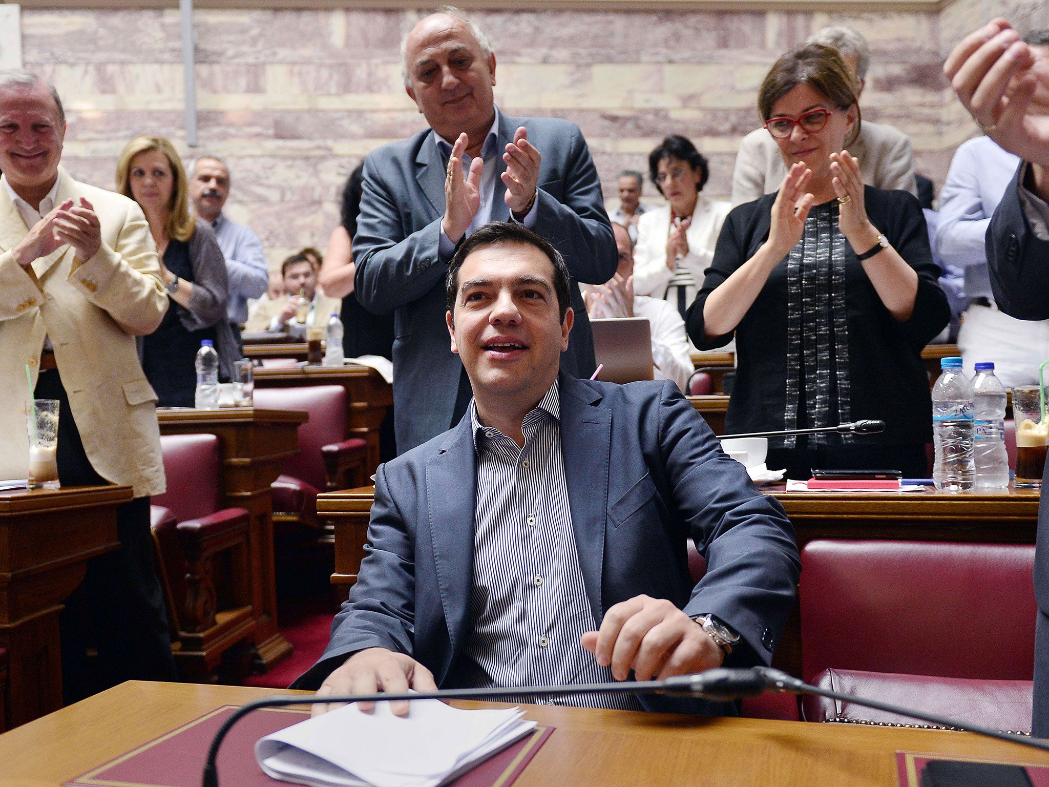 Greek prime minister Alexis Tsipras is applauded by lawmakers before addressing his parliamentary group meeting at the Greek Parliament in Athens
