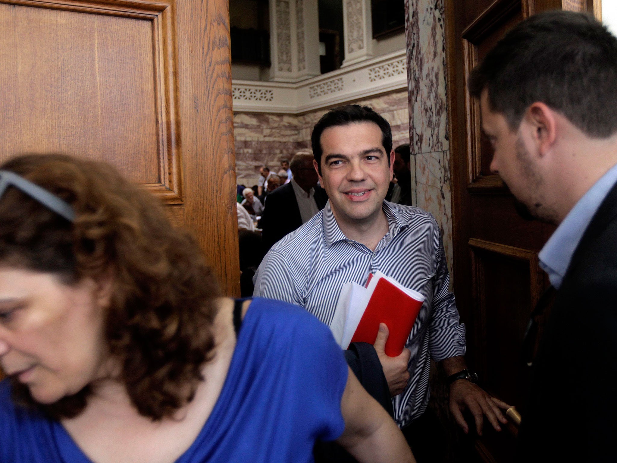 Alexis Tsipras (C) exits the meeting of the Parliamentary group of SYRIZA party in the Greek Parliament