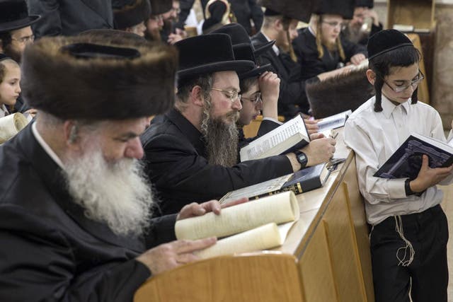 Ultra-Orthodox Jews read the Esther scrolls at a synagogue in the Israeli Mediterranean coastal city of Netanya