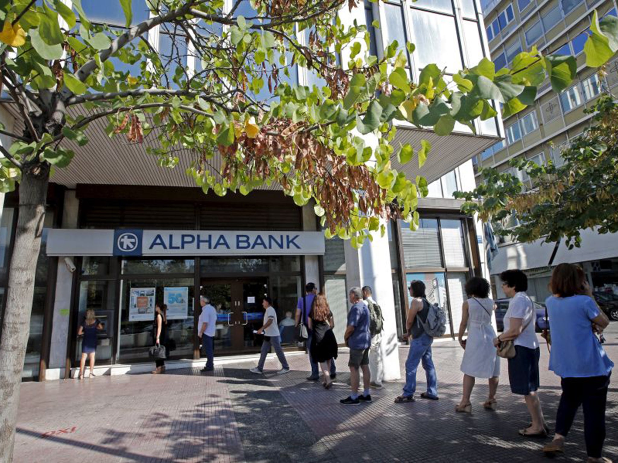 People queue at ATMs in Athens last week, but would they be better off without them?