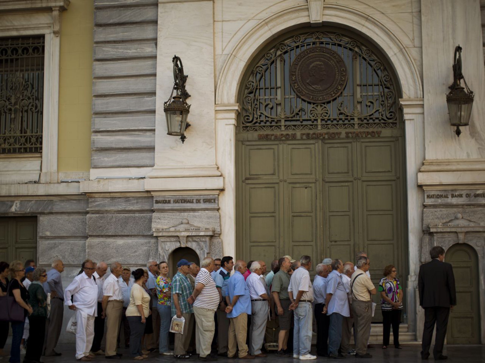 Pensioners wait outside the national bank of Greece. Shuttered banks are a striking physical symbol of economic disaster, but even they are not proof that the final dénouement is at hand