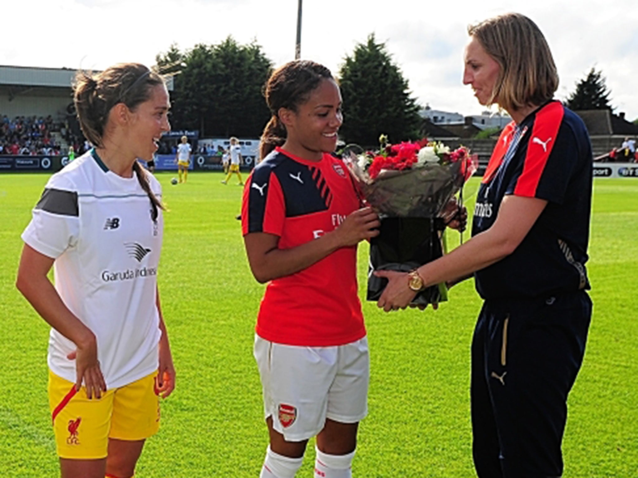 World Cup stars Fara Williams, of Liverpool, and Alex Scott, of Arsenal, are presented with flowers by former England captain Faye White