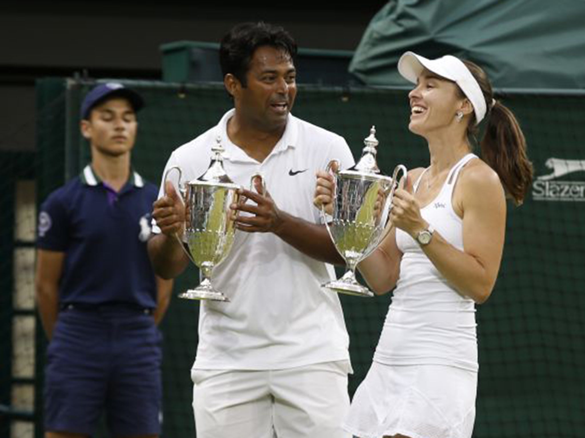 Martina Hingis, right, and Leander Paes hold aloft their trophies after winning the mixed doubles final in only 40 minutes