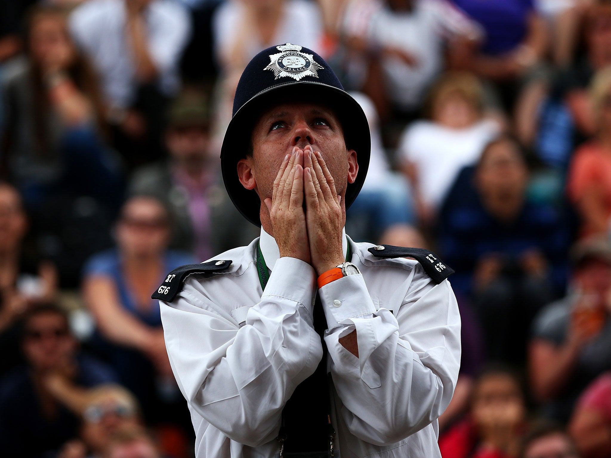 A policeman reacts during the Wimbledon men's singles final