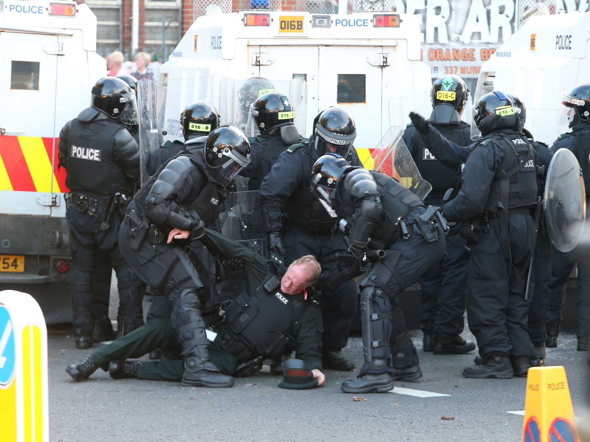An officer falls to the ground after being struck by a object from a protester