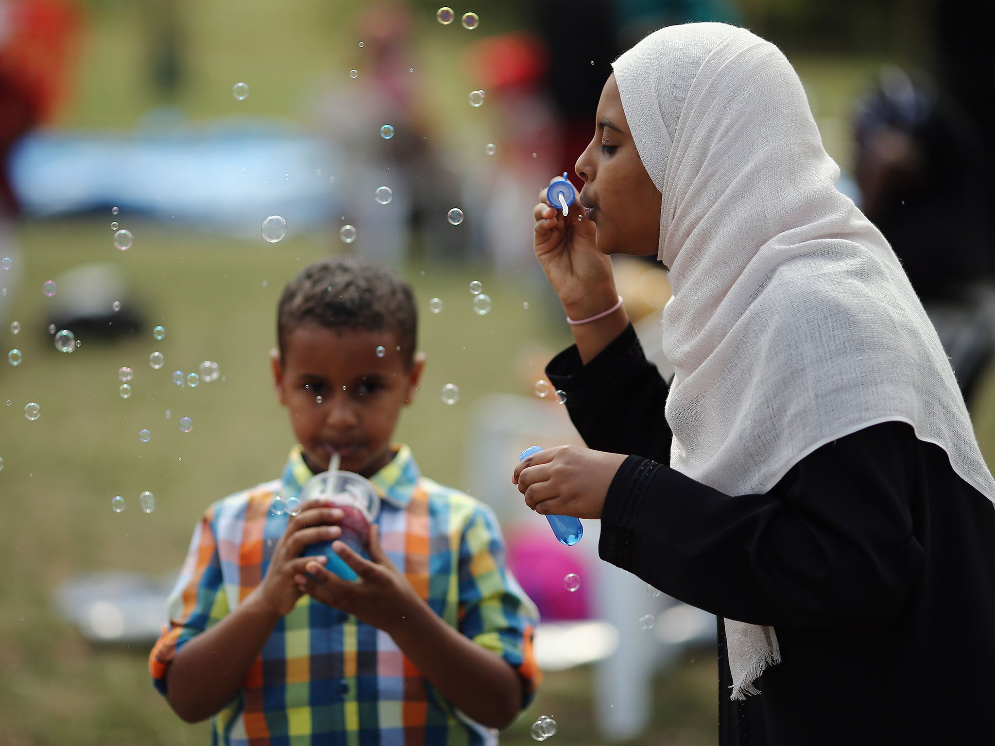 A girl blows bubbles during an Eid celebration in Burgess Park, London (Image: Getty)