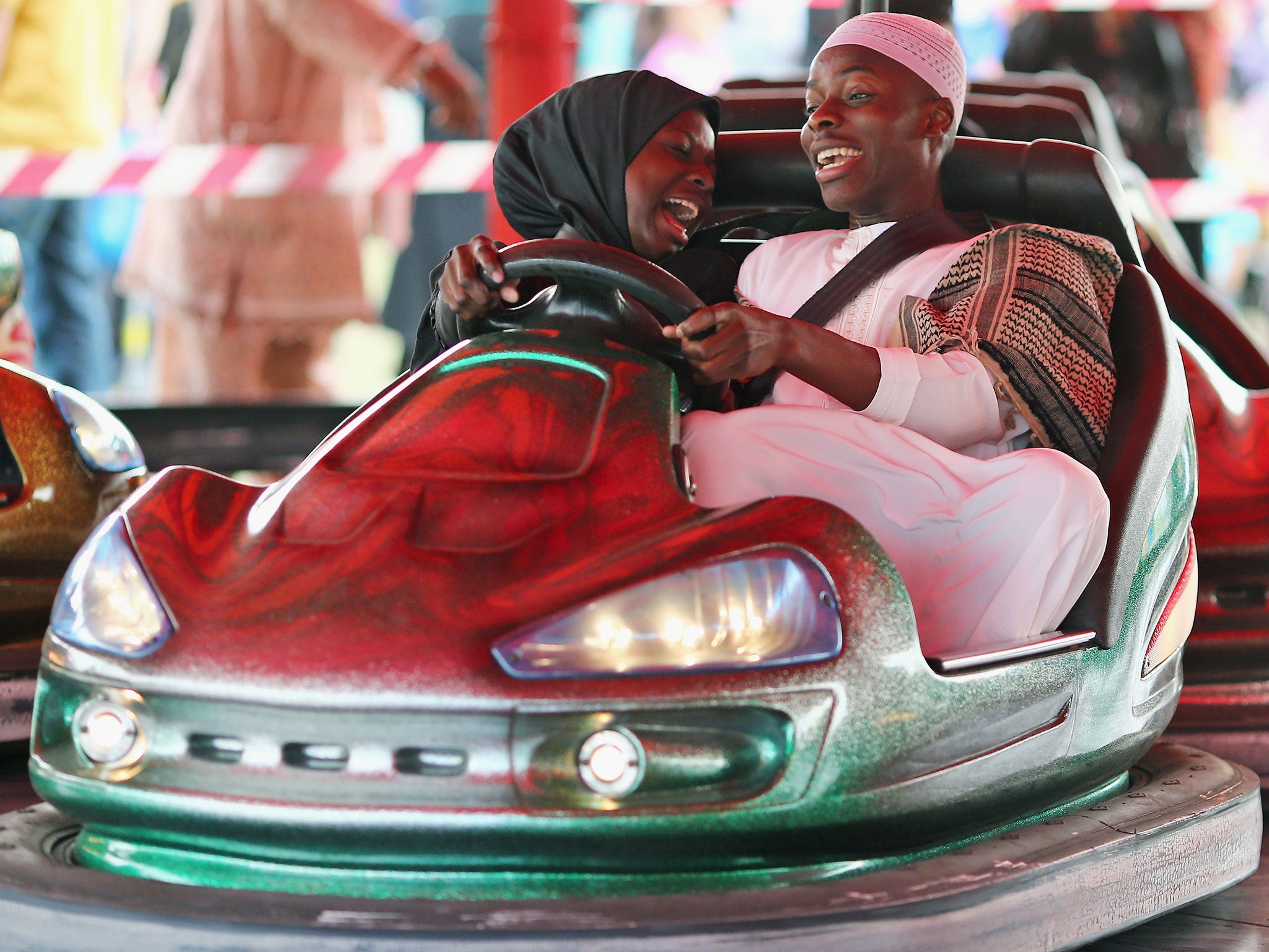People ride on Bumper cars during an Eid celebration in Burgess Park (Image: Getty)