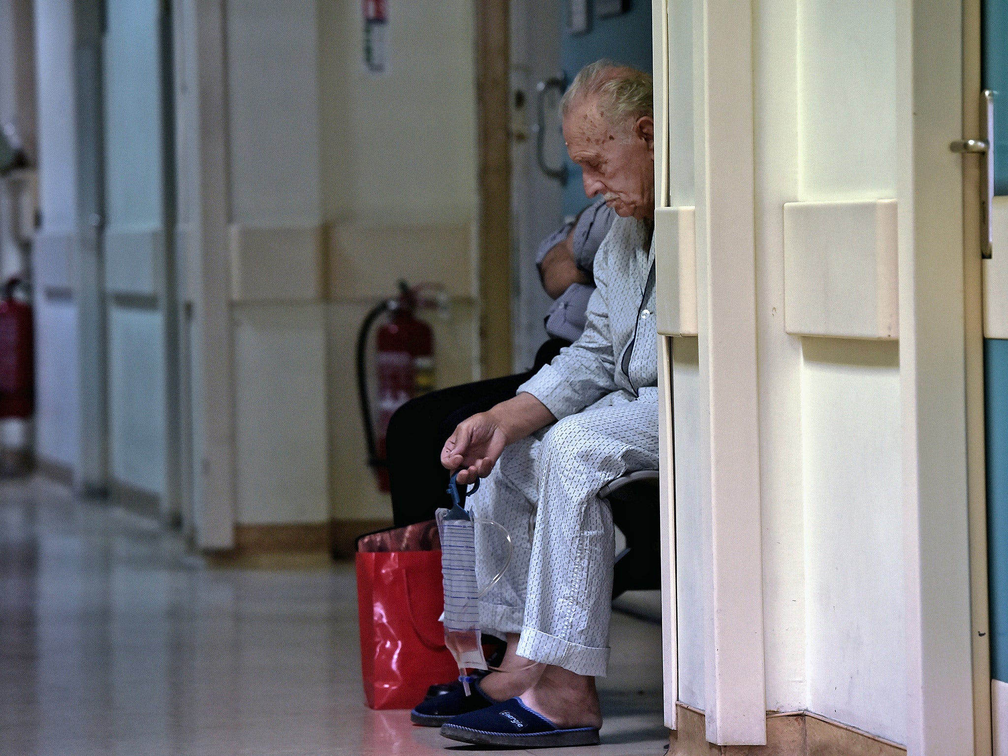 A patient sits in a corridor of an Athens hospital. File photo