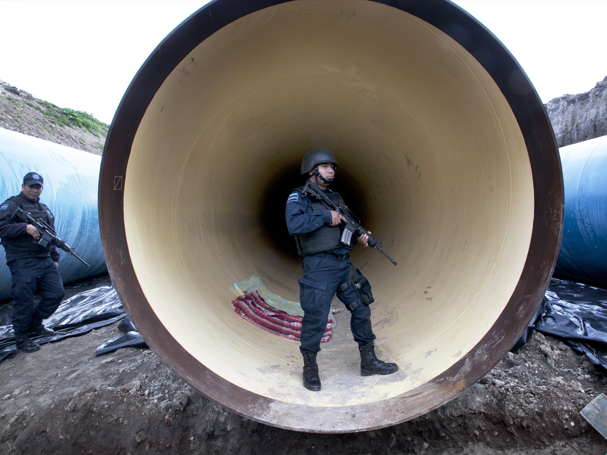 Federal police guard a drainage pipe outside of the Altiplano maximum security prison in Almoloya