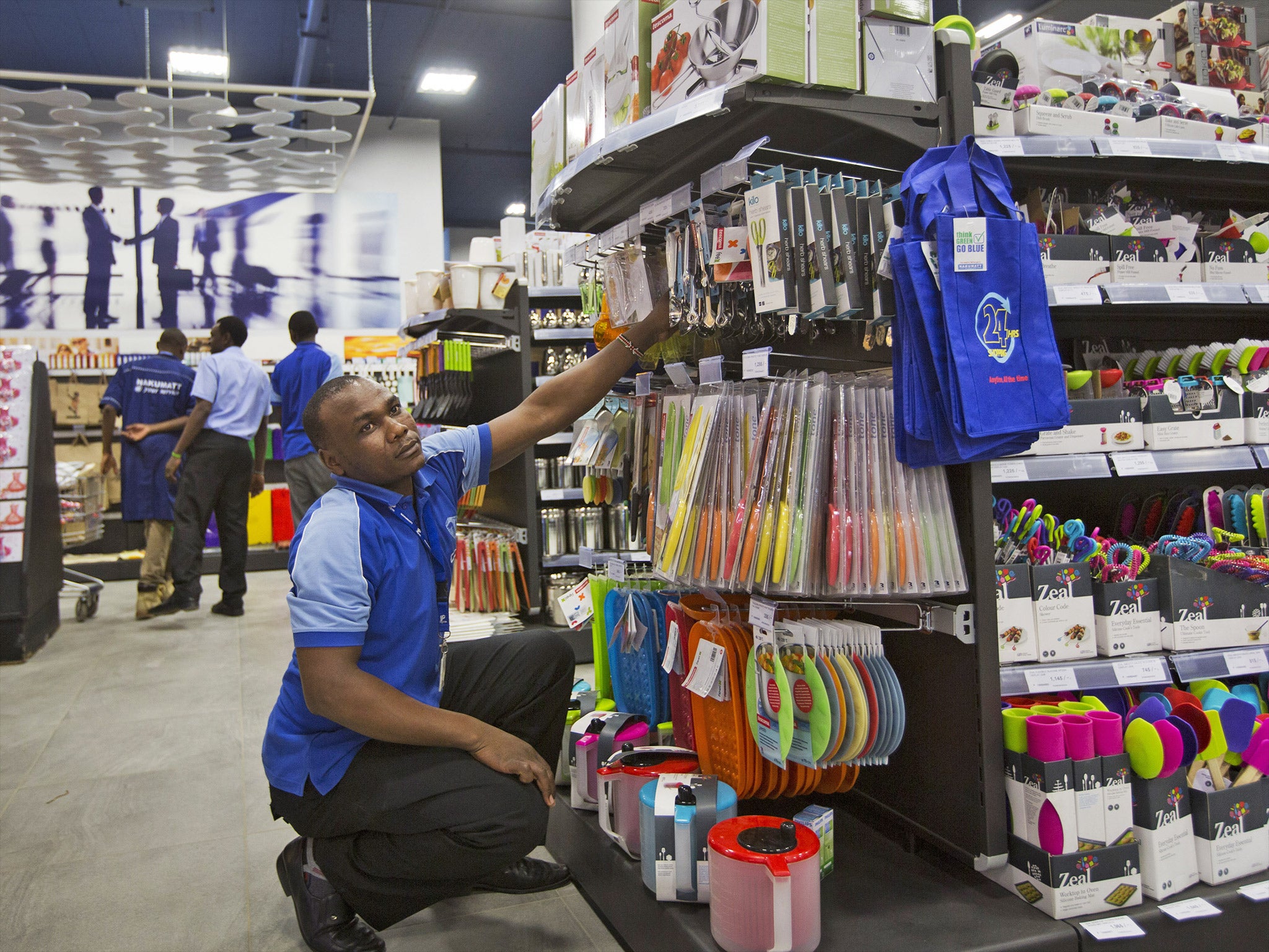 A supermarket worker stock shelves in the Westgate Mall, prior to it being re-opened to the public