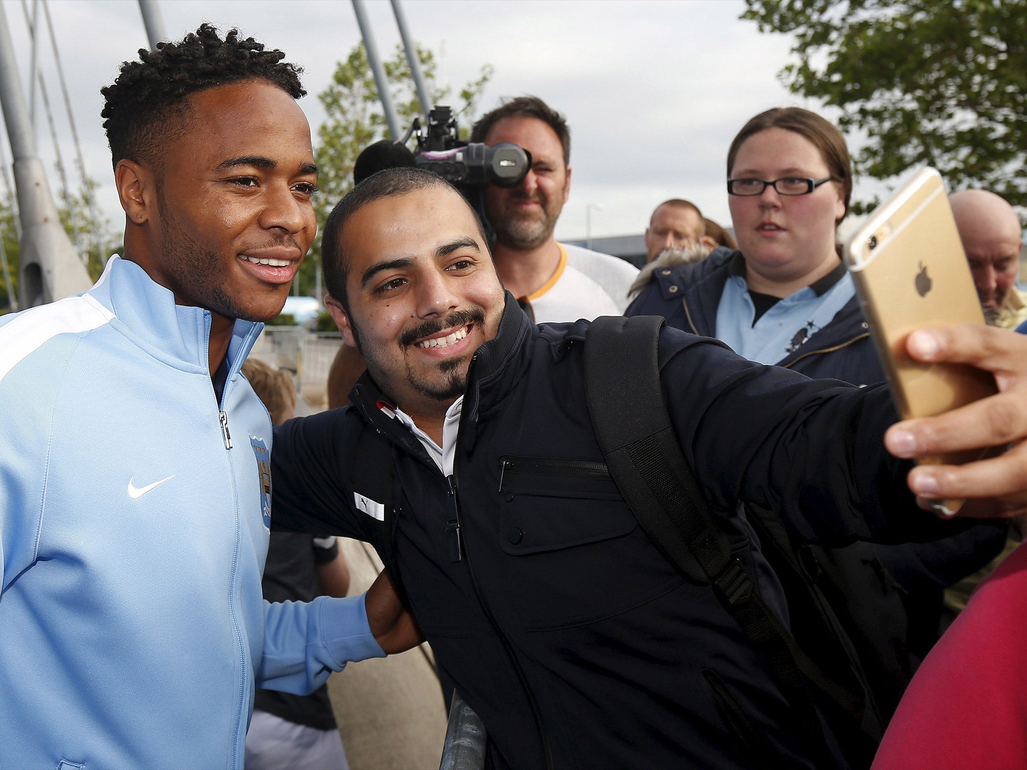 Raheem Sterling has his picture taken with a fan as he arrives at the Etihad Stadium on Tuesday