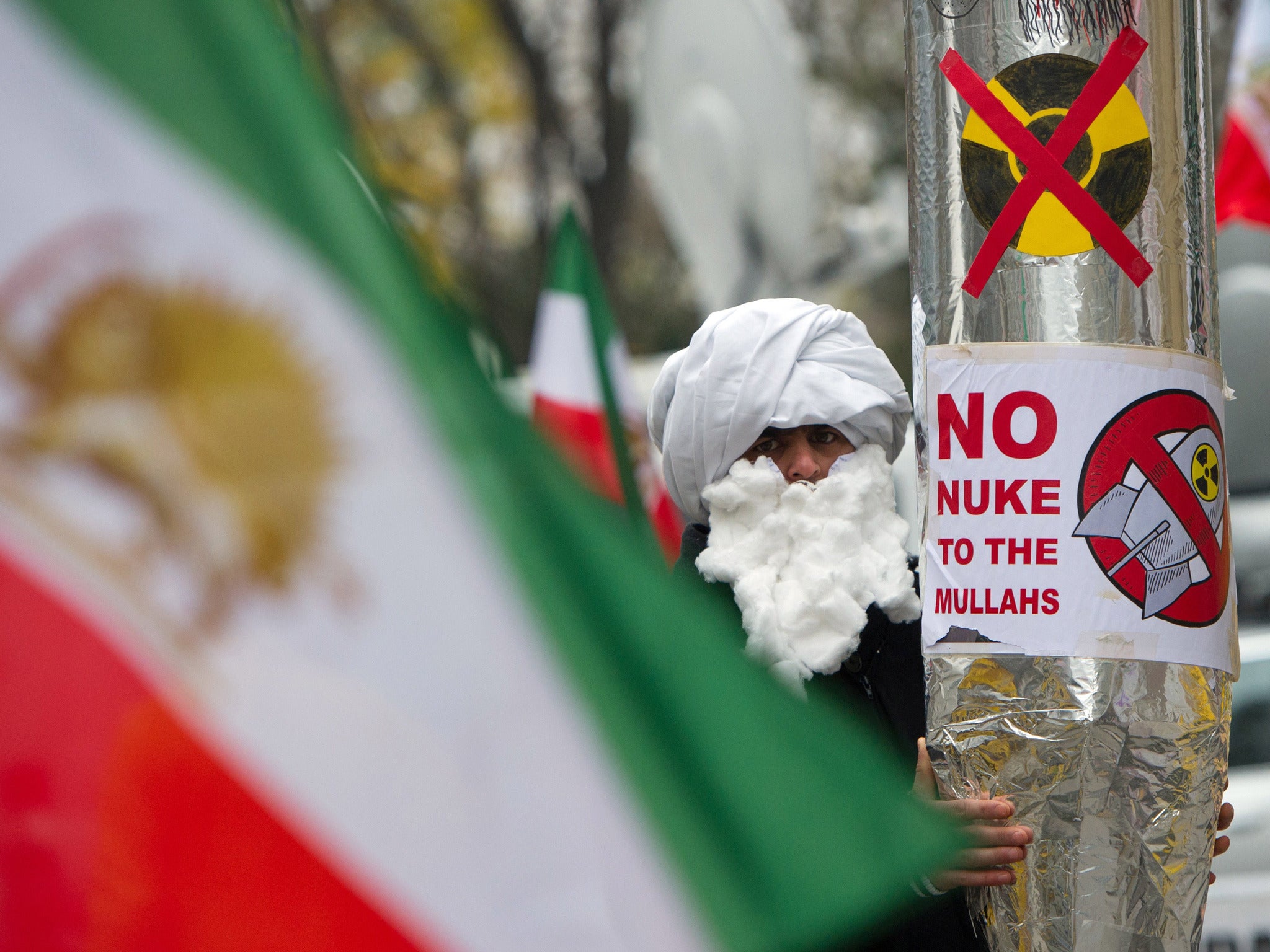 A demonstrator holds a mock-up of a nuclear missile as he protests against Iran's nuclear program and regime in front the Palais Coburg in Vienna
