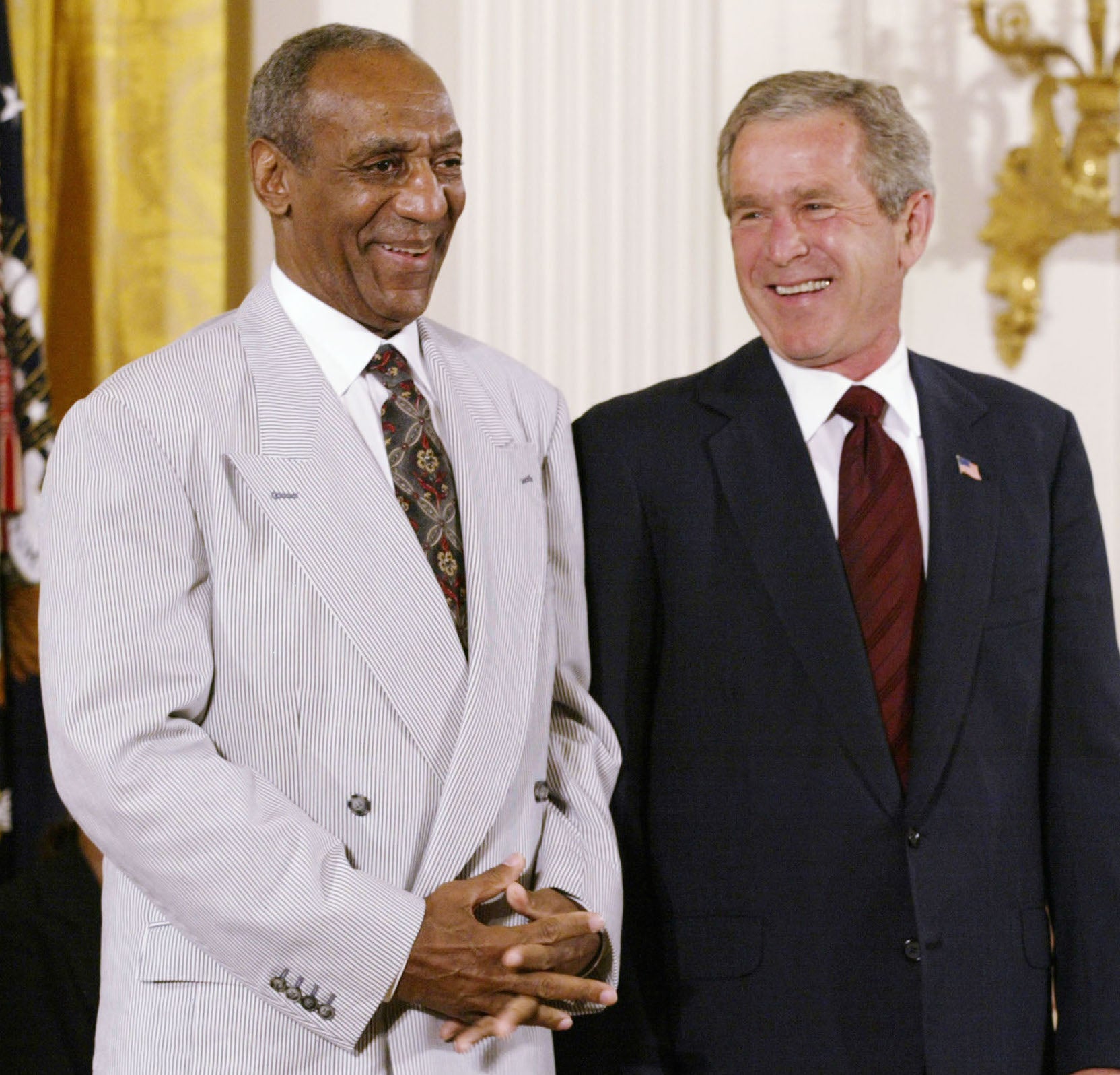 Comedian Bill Cosby checks out baseball legend Hank Aaron who received the Medal of Honor at the White House on July 9, 2002.