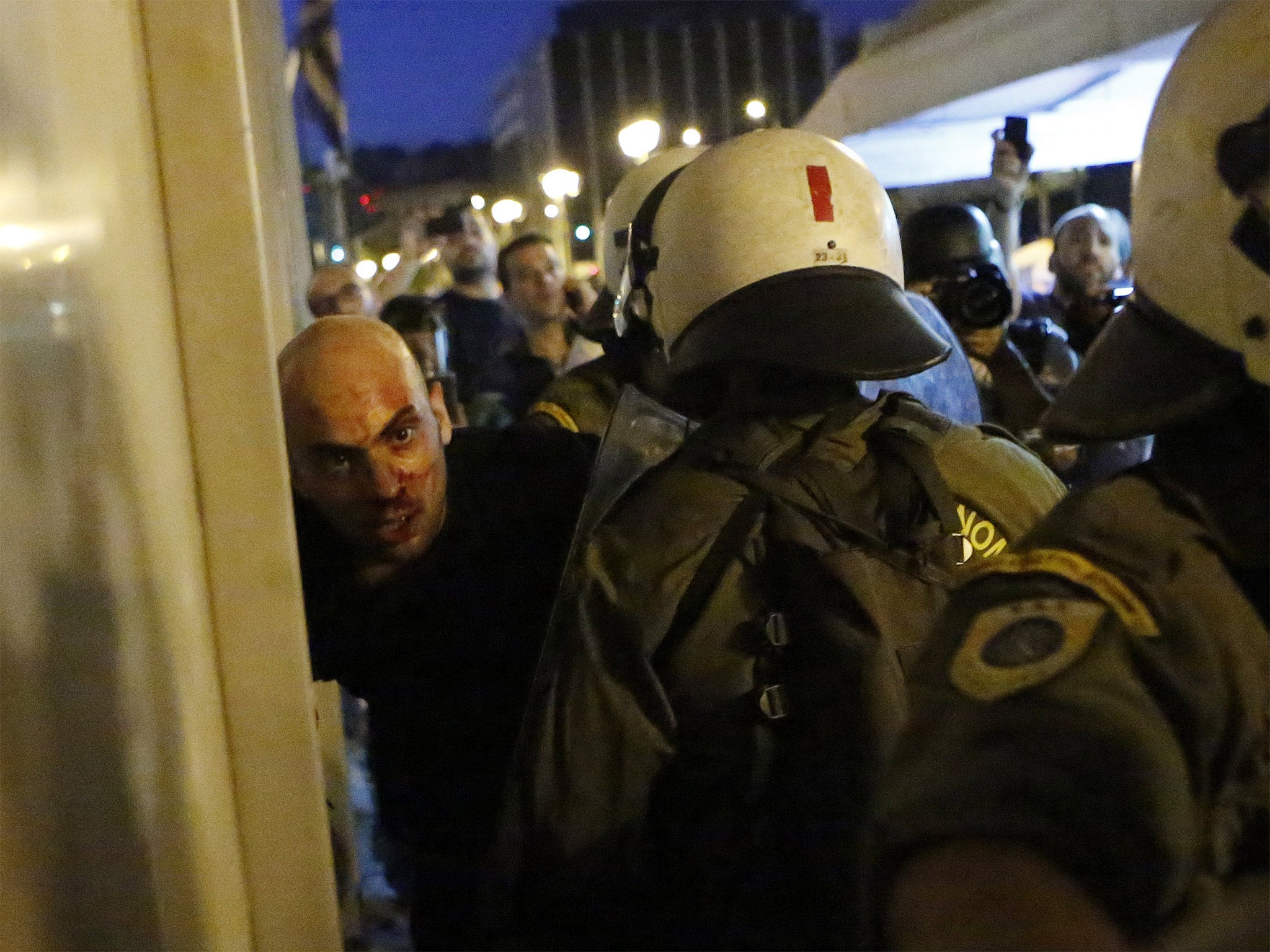 Riot police detain an anti-austerity protester in Athens on Wednesday night