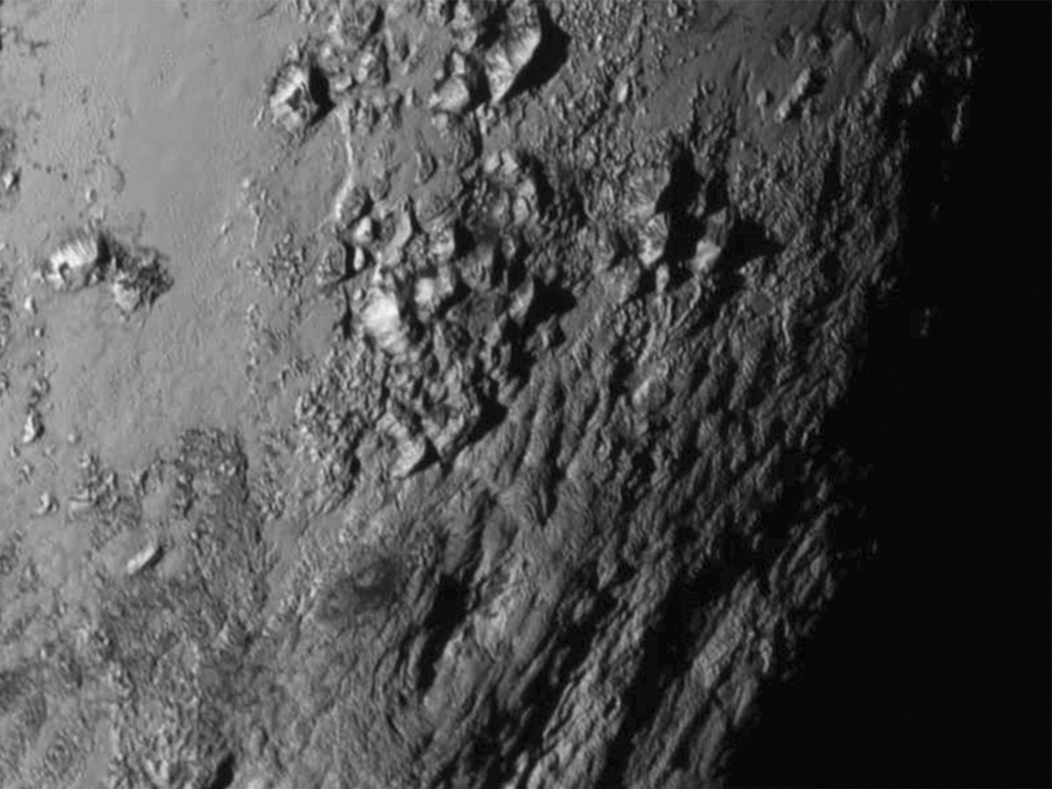 A close-up image of a region near Pluto's equator reveals a range of youthful mountains rising as high as 11,000 feet (3,500 meters) above the surface of the icy body