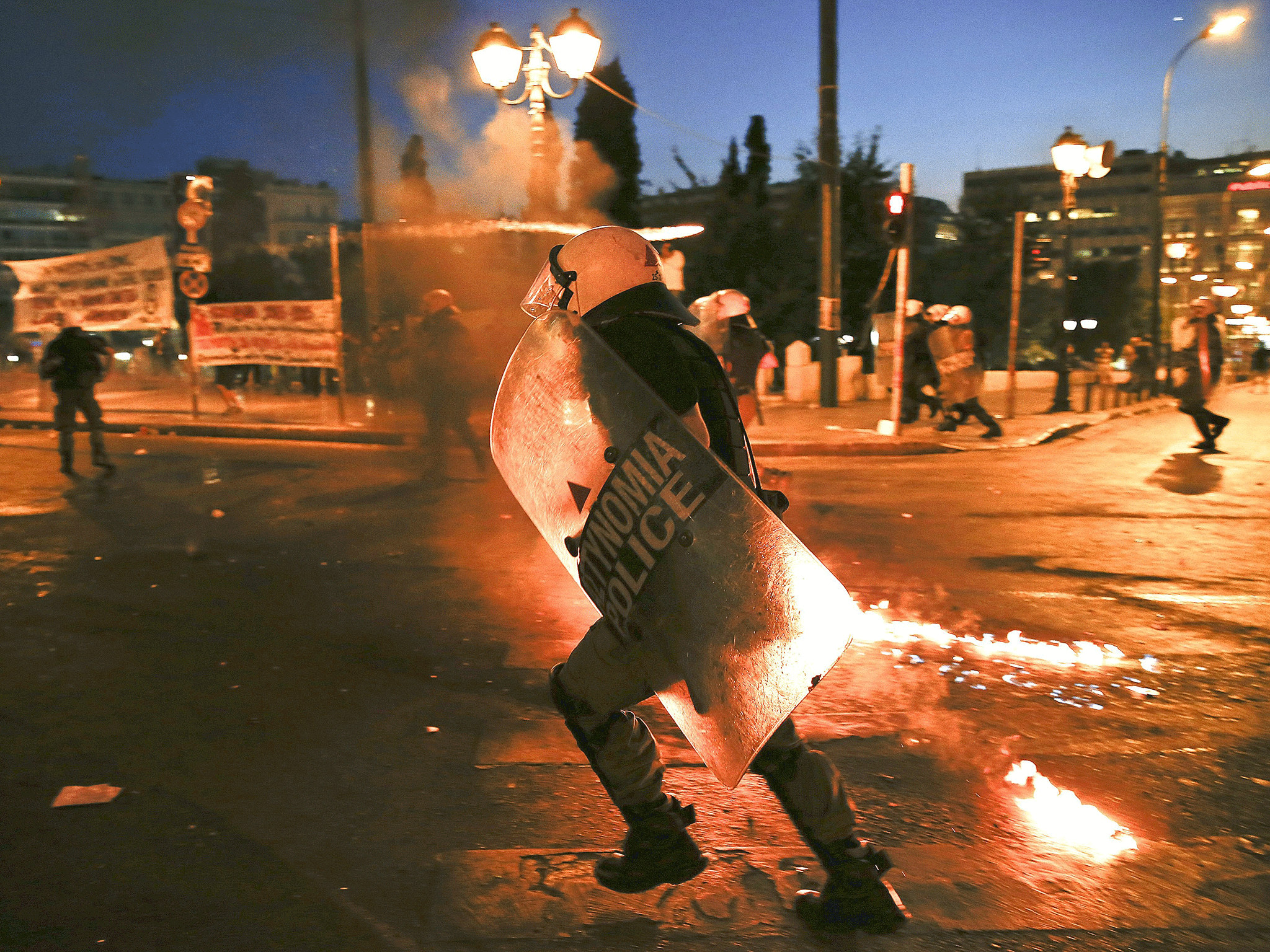 Riot police run as they disperse protesters during clashes in Athens on July 15