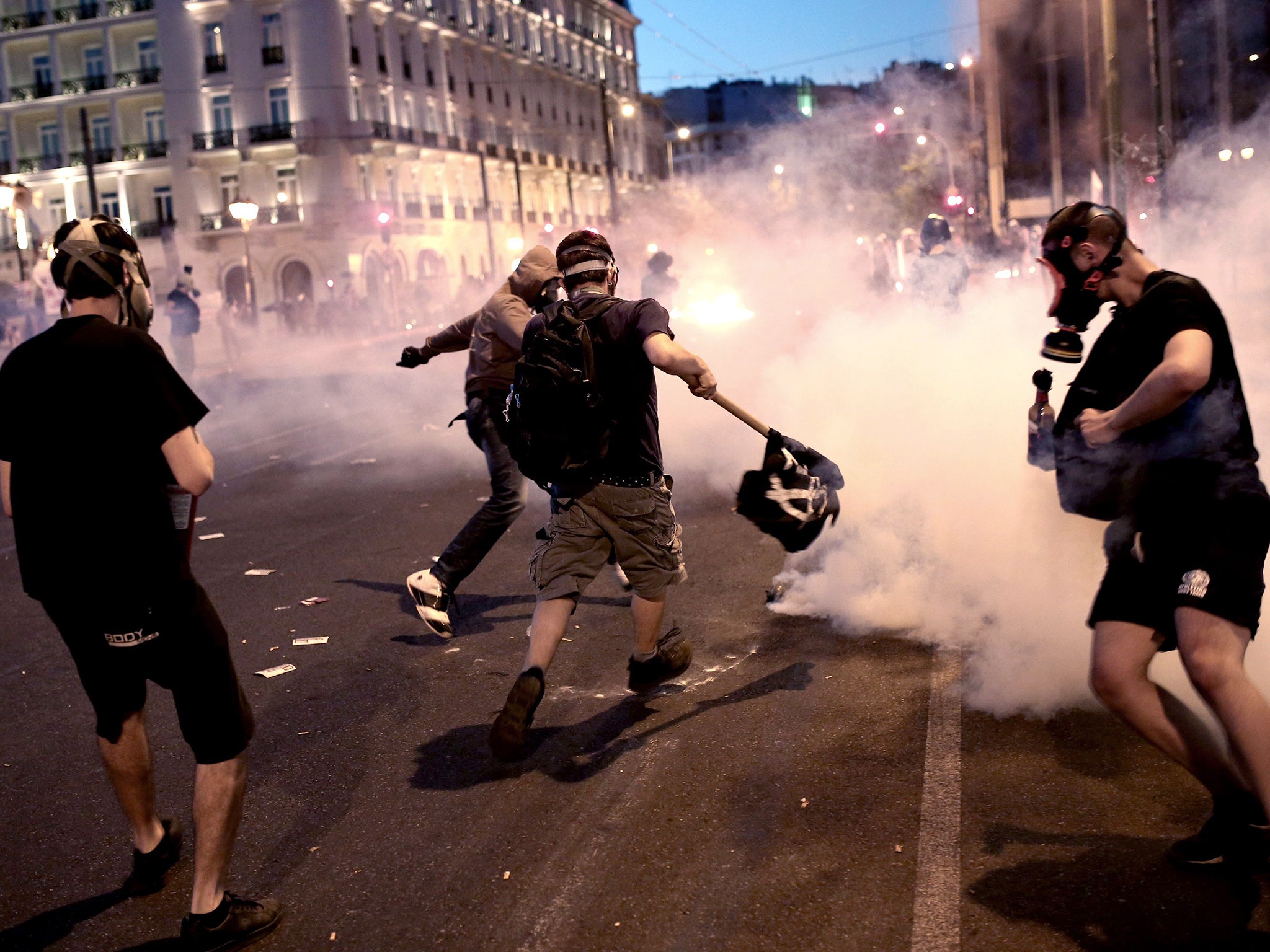 Protesters clash with riot police in front of the Greek Parliament