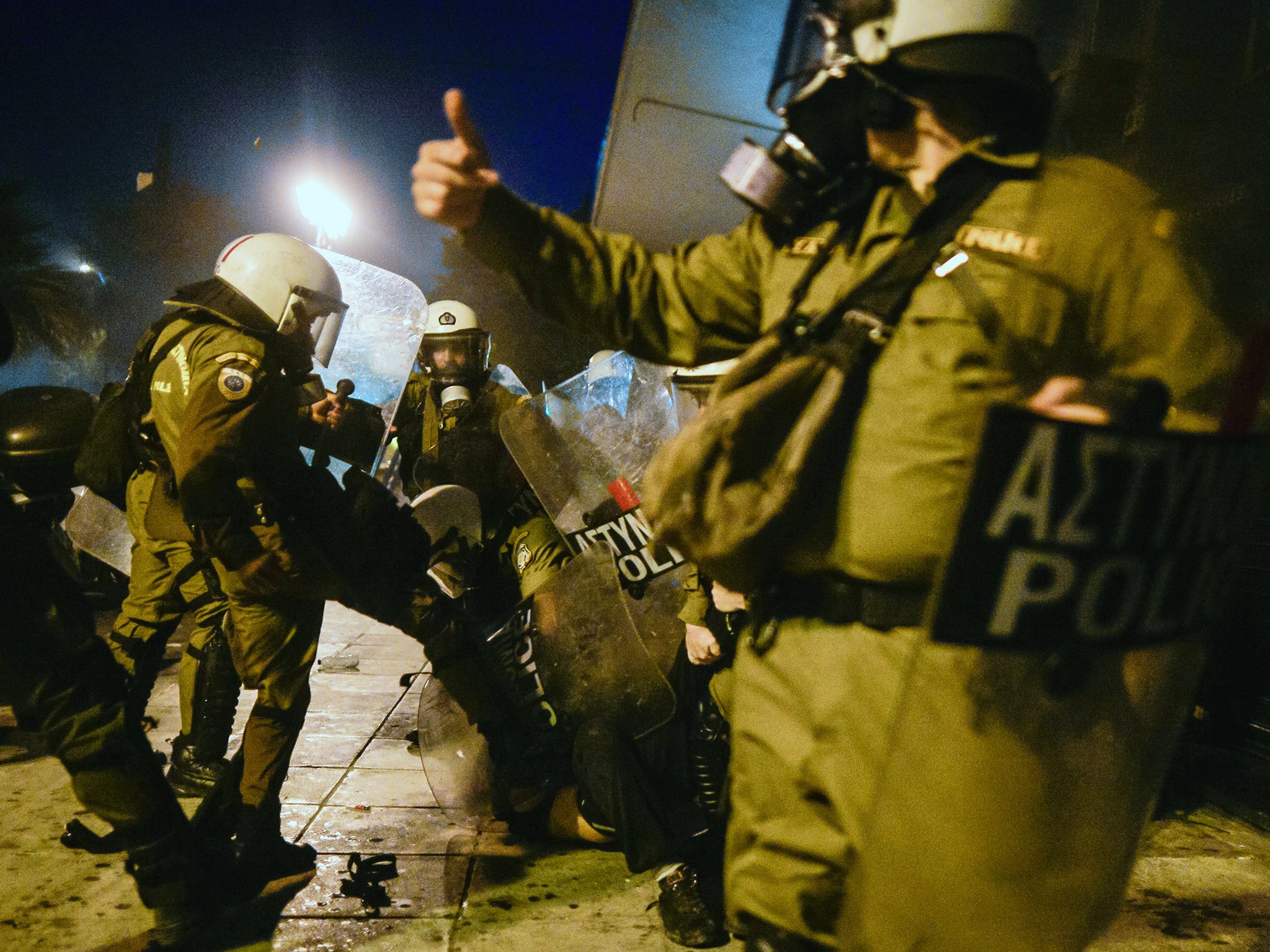 Riot policemen arrest a protester during an anti-austerity protest in front of the Greek parliament