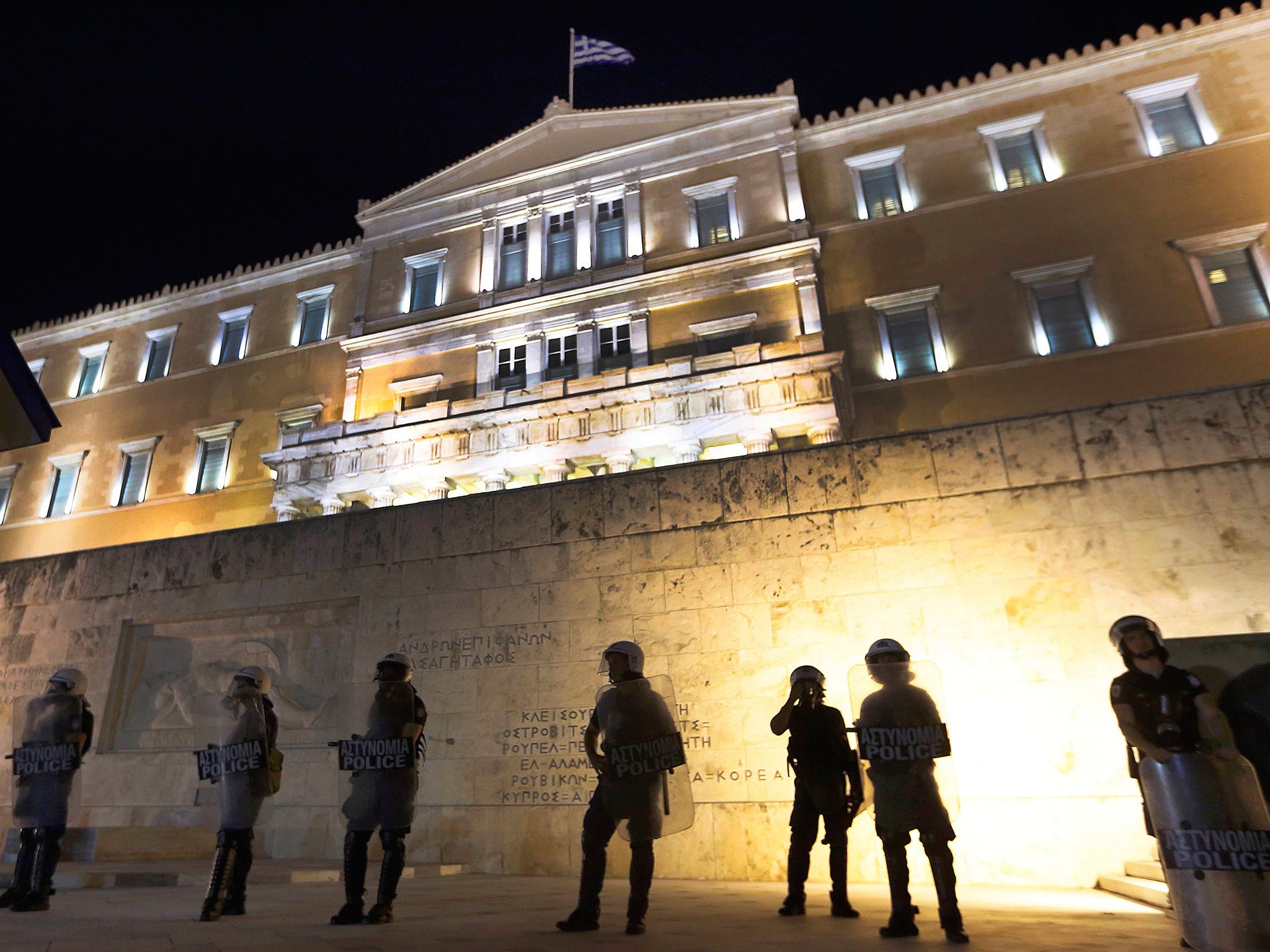 Riot policemen stand guard in front of the Greek Parliament during clashes