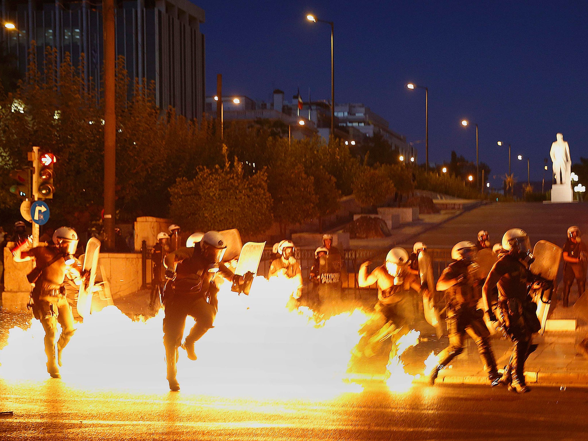 Riot policemen try to avoid an exploding petrol bomb during clashes