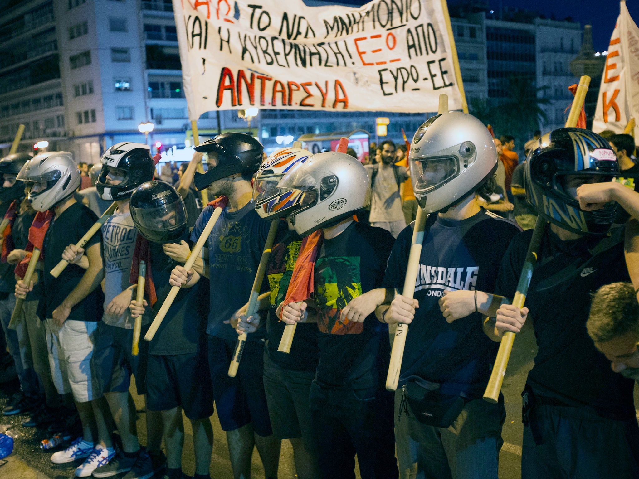 Anti-austerity protesters march in front of the parliament after clashes