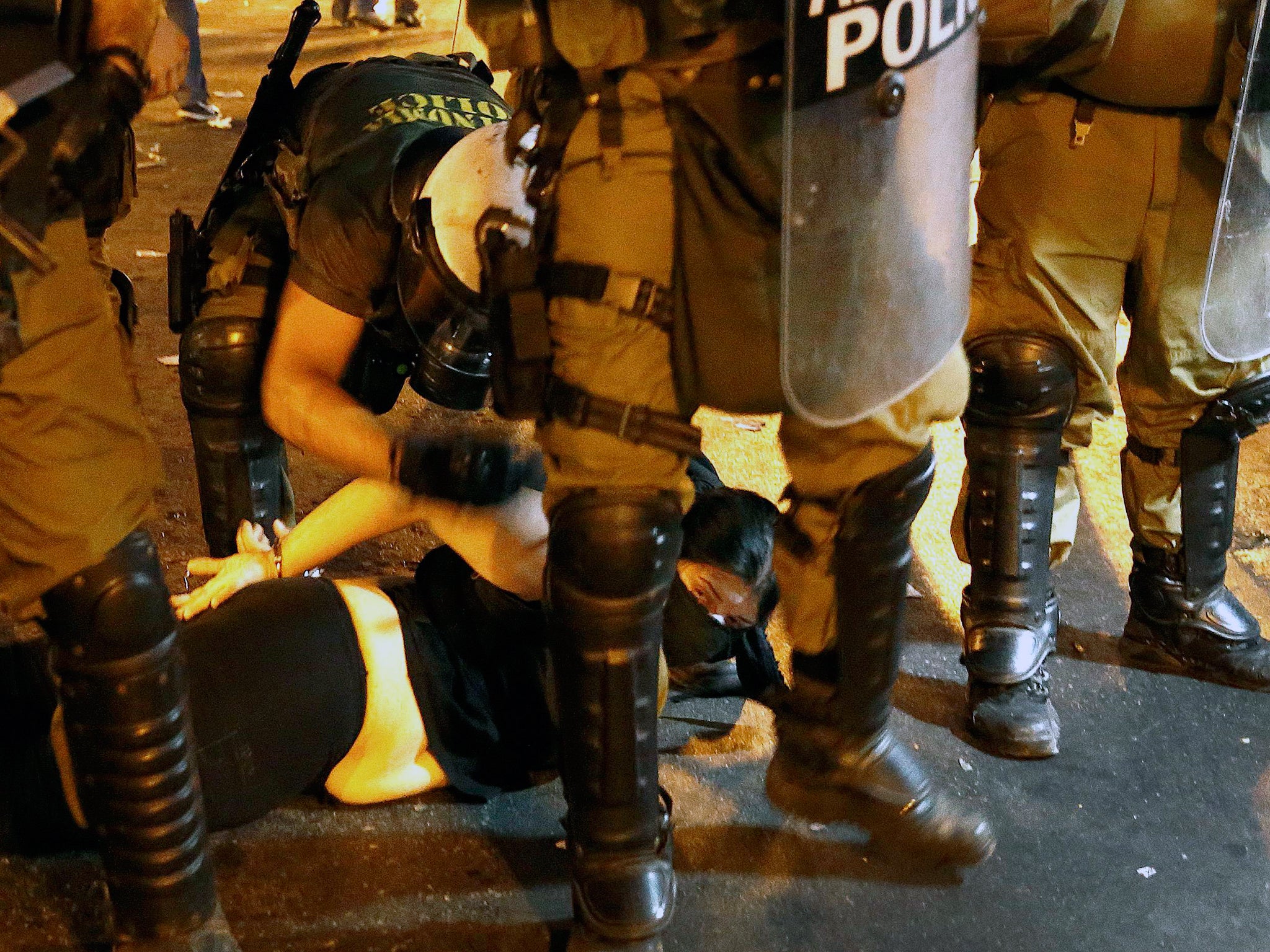 A protester is arrested by riot police following clashes