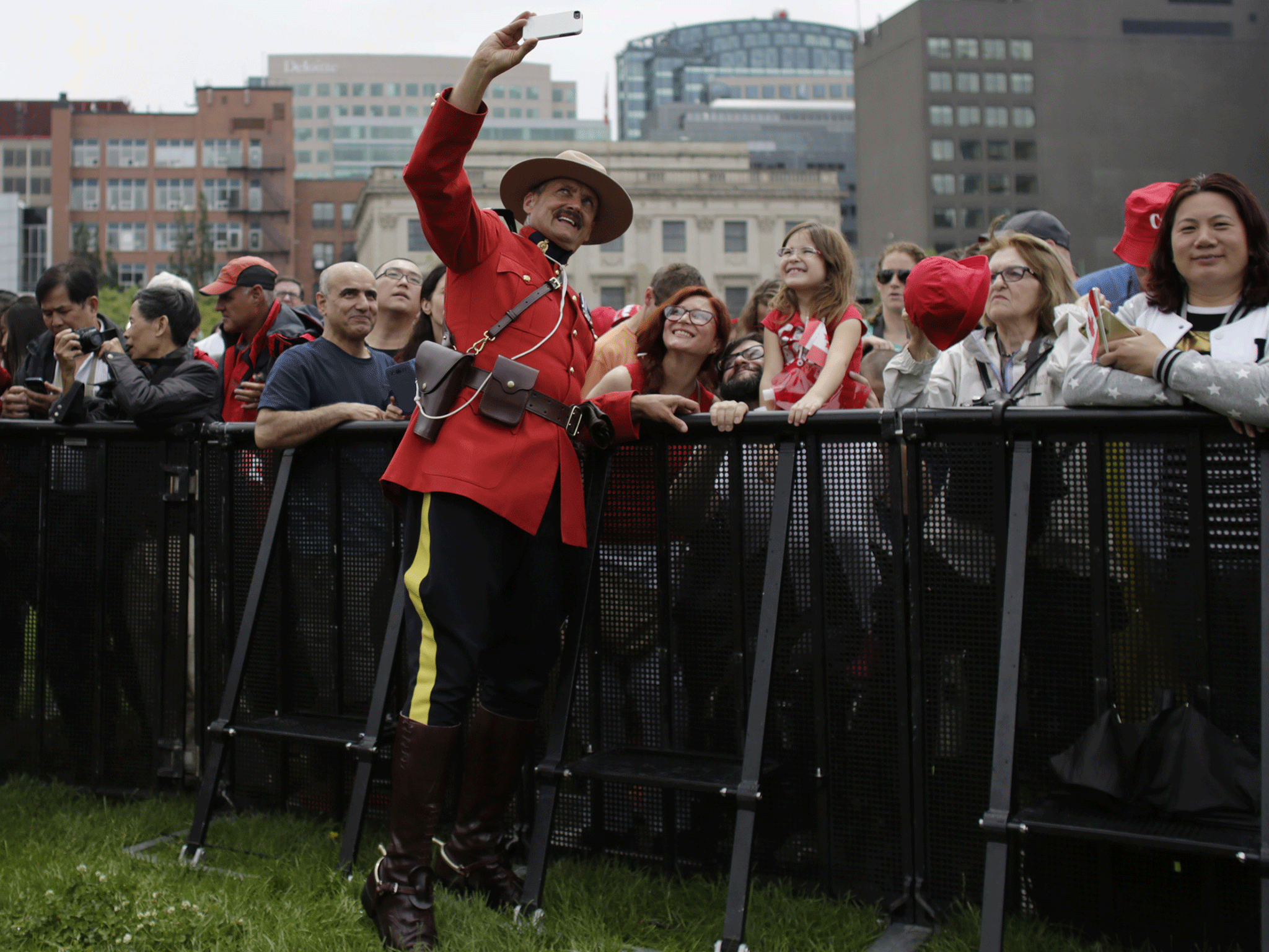 A Royal Canada Mounted Police officer takes a selfie during Canada Day festivities on Parliament Hill on 1 July, 2015