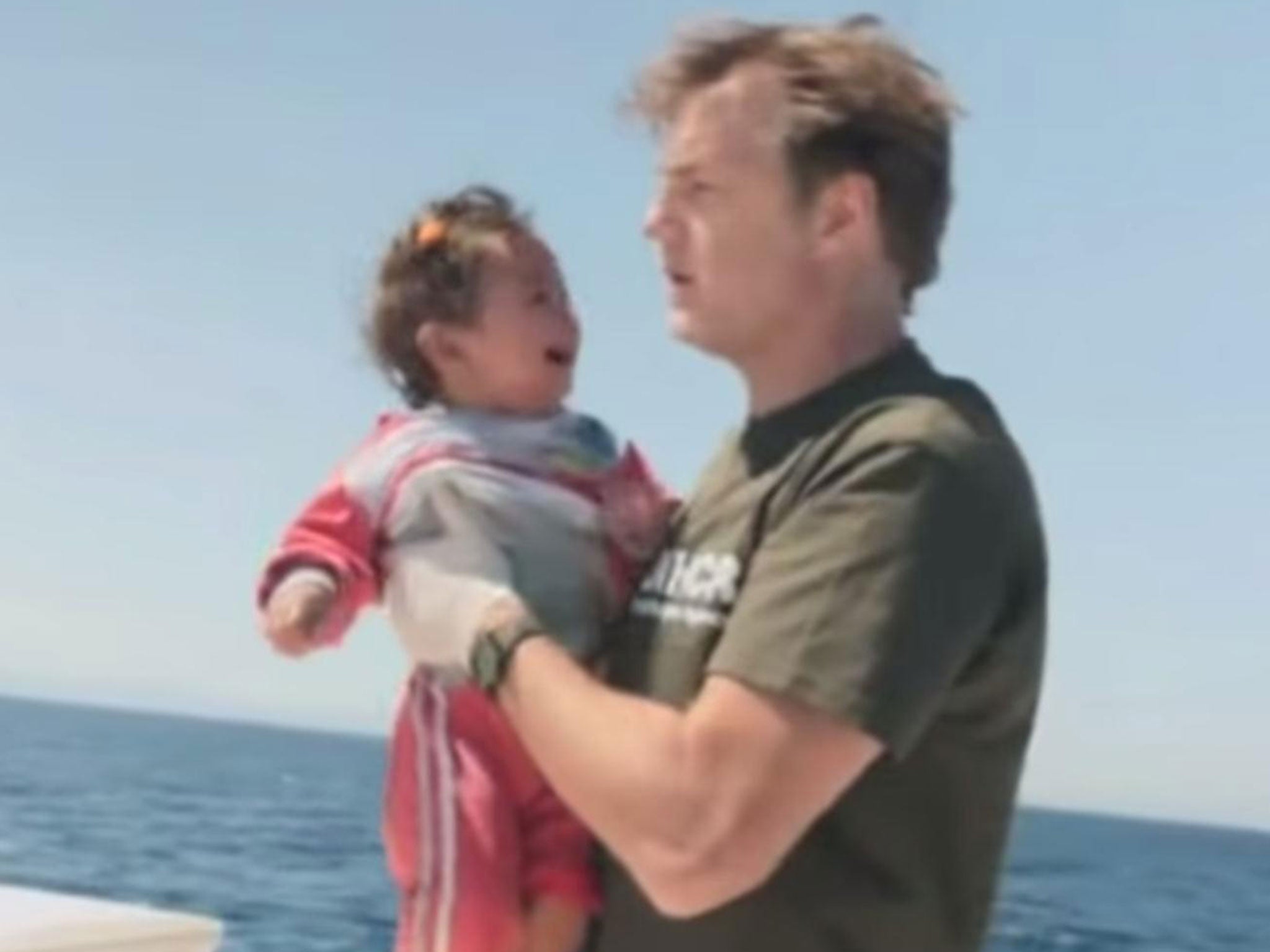 Morrissey pulls a child to safety in Lesvos, Greece