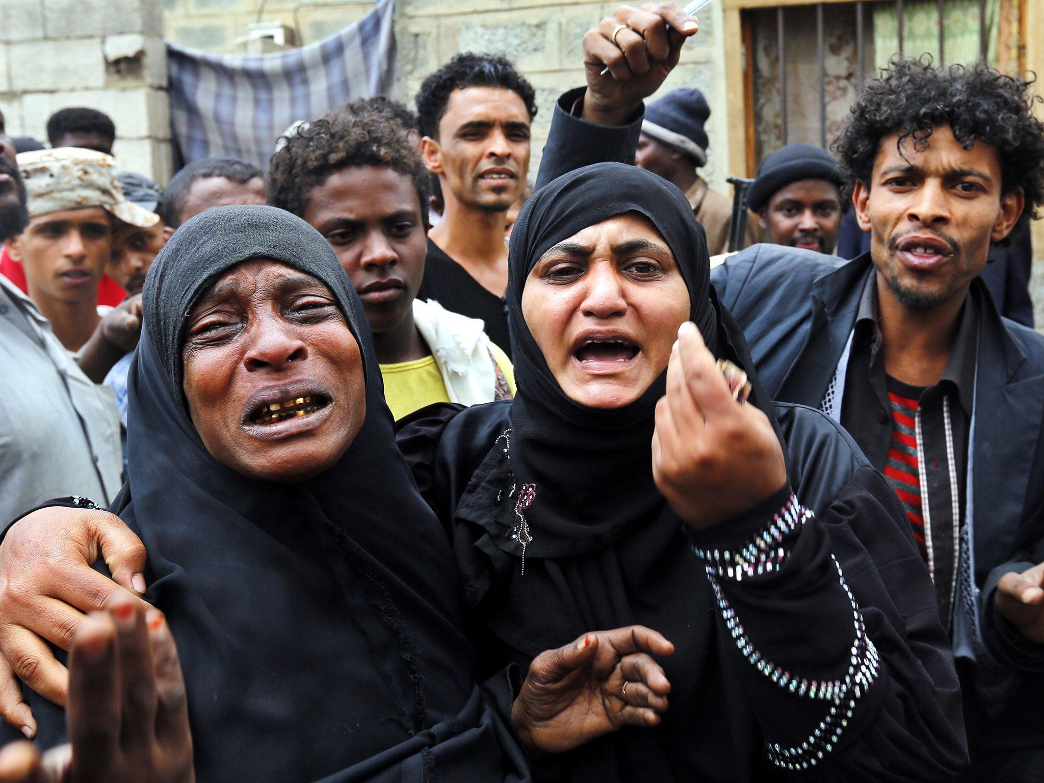 Yemenis react after air strikes carried out by the Saudi-led coalition killed dozens in Sanaa