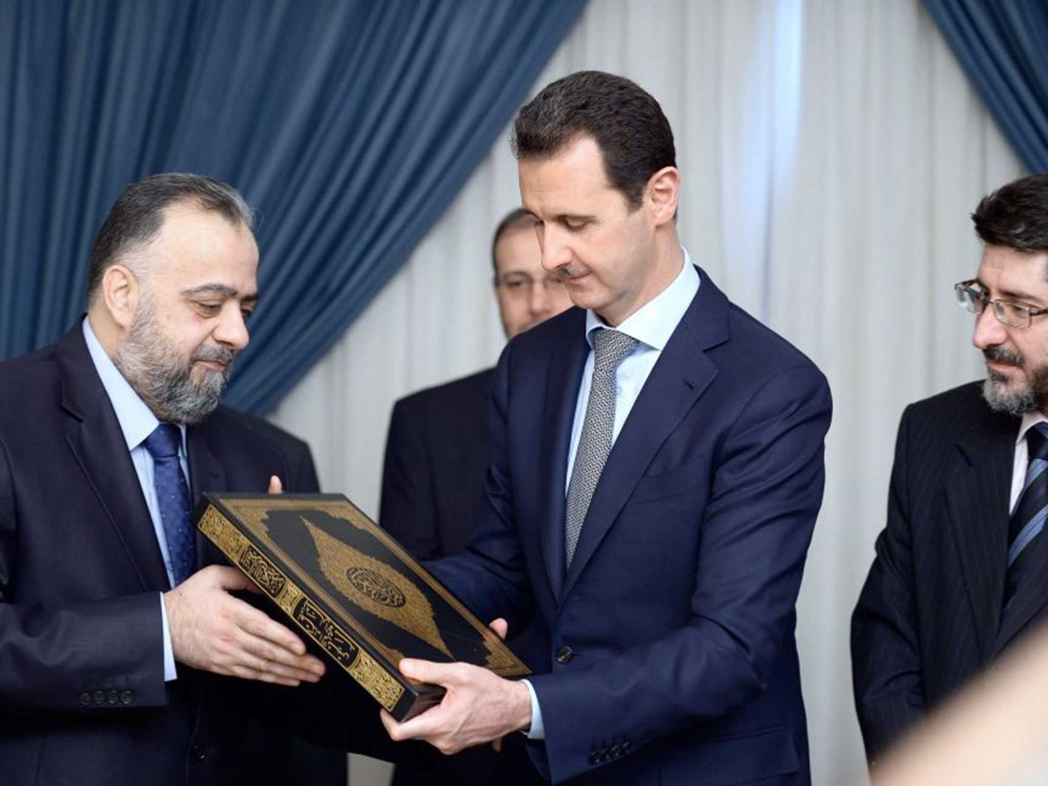 al-Assad is handed a new standard version of the Koran by Srian Minister Religious Endowments (Awqaf)
