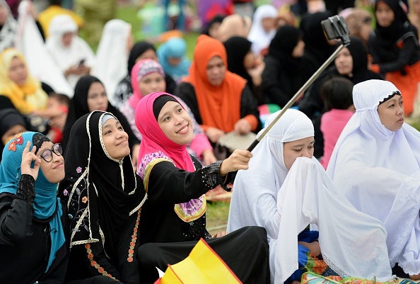 Young women take a 'selfie' prior to Eid prayers at a park in Manila, Philippines (via TED ALJIBE/AFP/Getty Images)