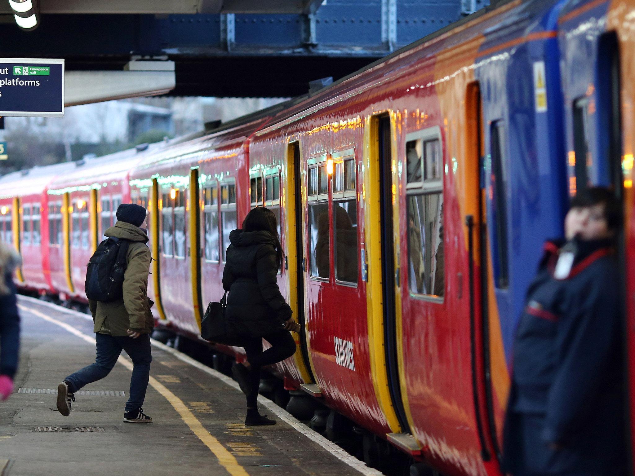 LONDON, ENGLAND - JANUARY 02: Passengers run to board a train at Clapham Junction on January 2, 2015 in London, England. Increased rail fares averaging 2.5% come into effect today, pushing the cost of some commuters annual rail fares to more than £5,000.
