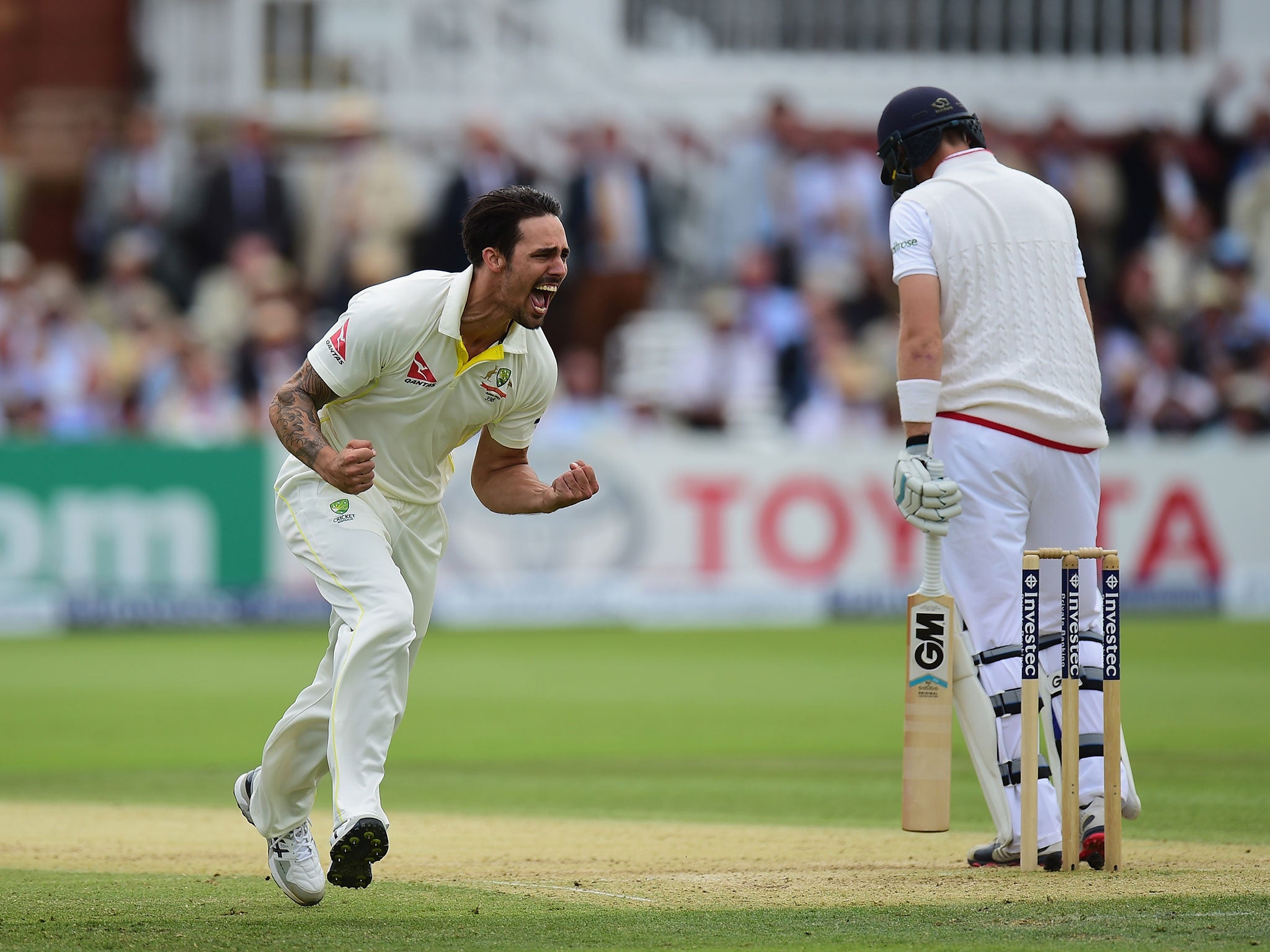 Mitchell Johnson of Australia celebrates after taking the wicket of Joe Root