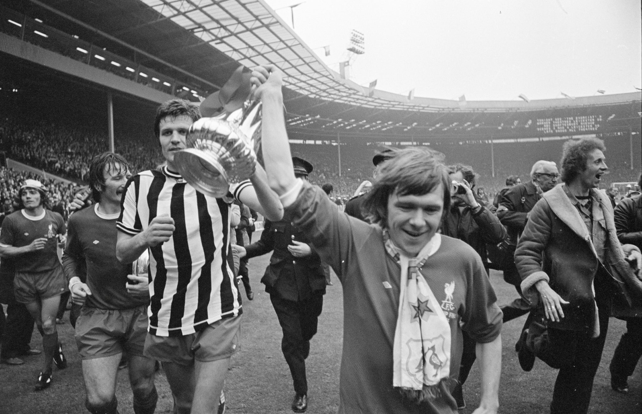 Liverpool players John Toshack (L) and Brian Hall (R) parade the winning trophy after the 1974 FA Cup Final