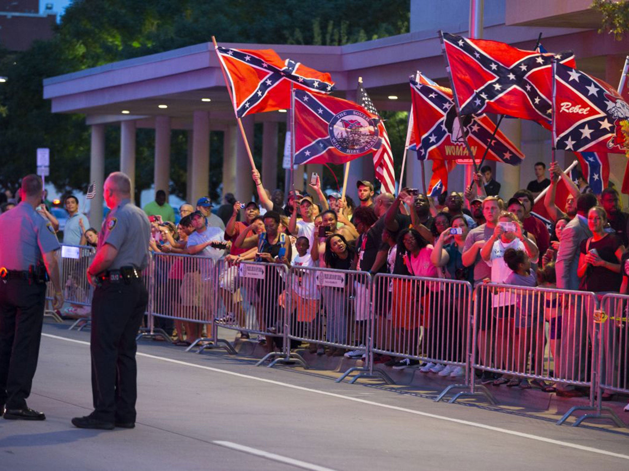People wave Confederate flags outside the hotel that President Barack Obama is staying the night, on Wednesday, July 15, 2015, in Oklahoma City.