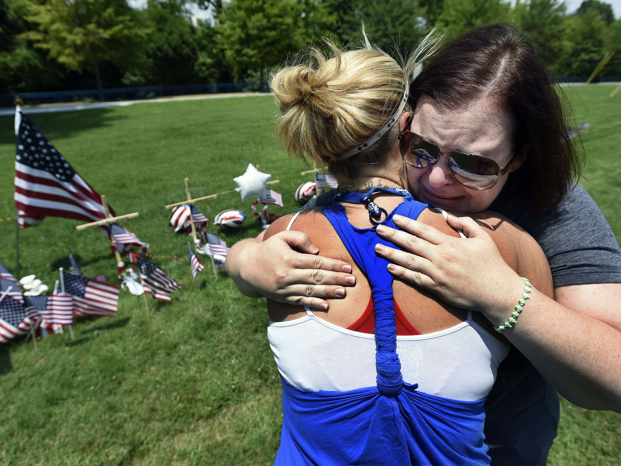 Sophia Ensley, left, comforts Barbie Branum by a makeshift memorial at the Marine Reserve Center in Chattanooga, Tennessee