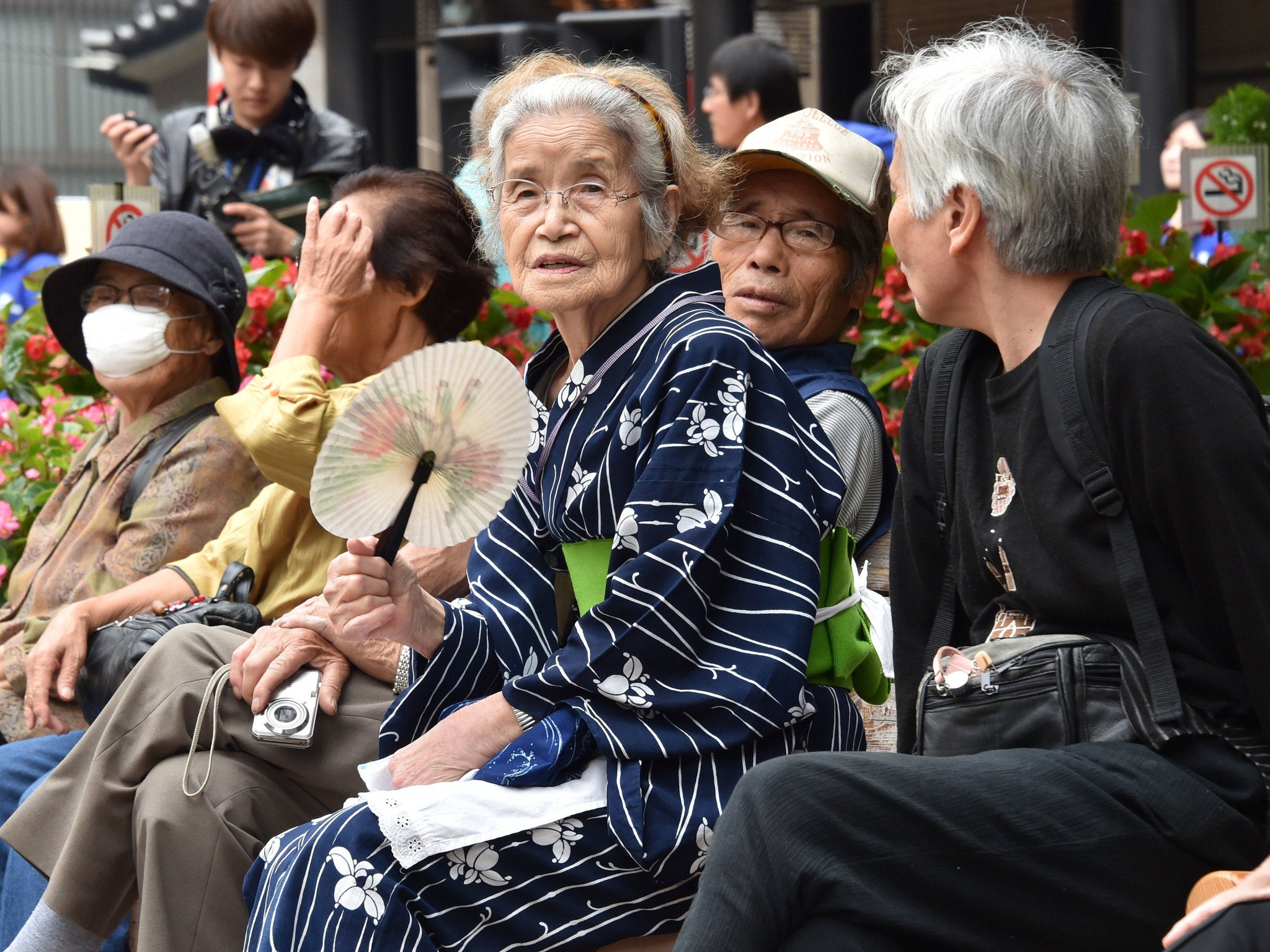 Elderly residents rest in the grounds of a temple in Tokyo on September 15, 2014 as the country marks Respect-for-the-Aged-Day. The number of people aged 65 or older in Japan is at a record 32.96 million, accounting for an all-time high of 25.9 percent of the nation's total population, the government announced. AFP PHOTO / Yoshikazu TSUNO