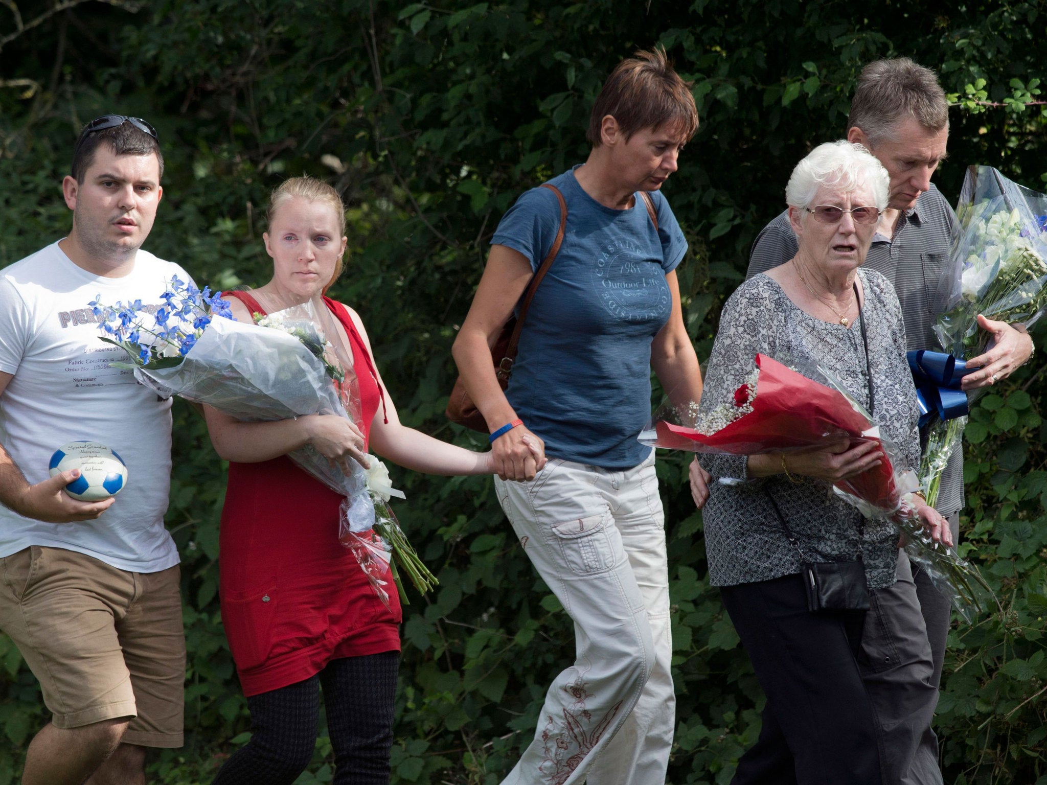 Family members lay flowers at the scene where Don Lock was stabbed