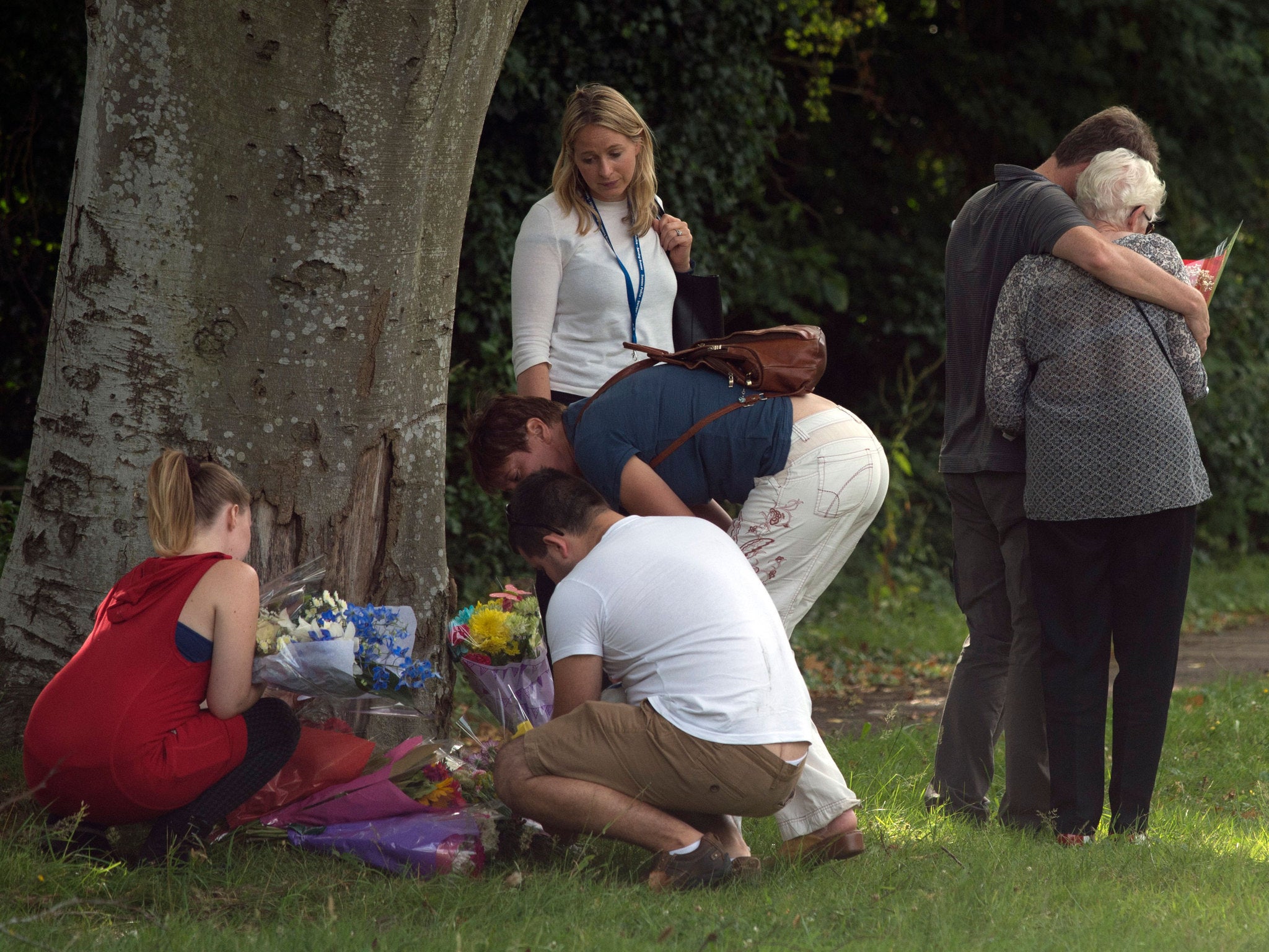 Family members lay flowers at the scene where Don Lock was stabbed