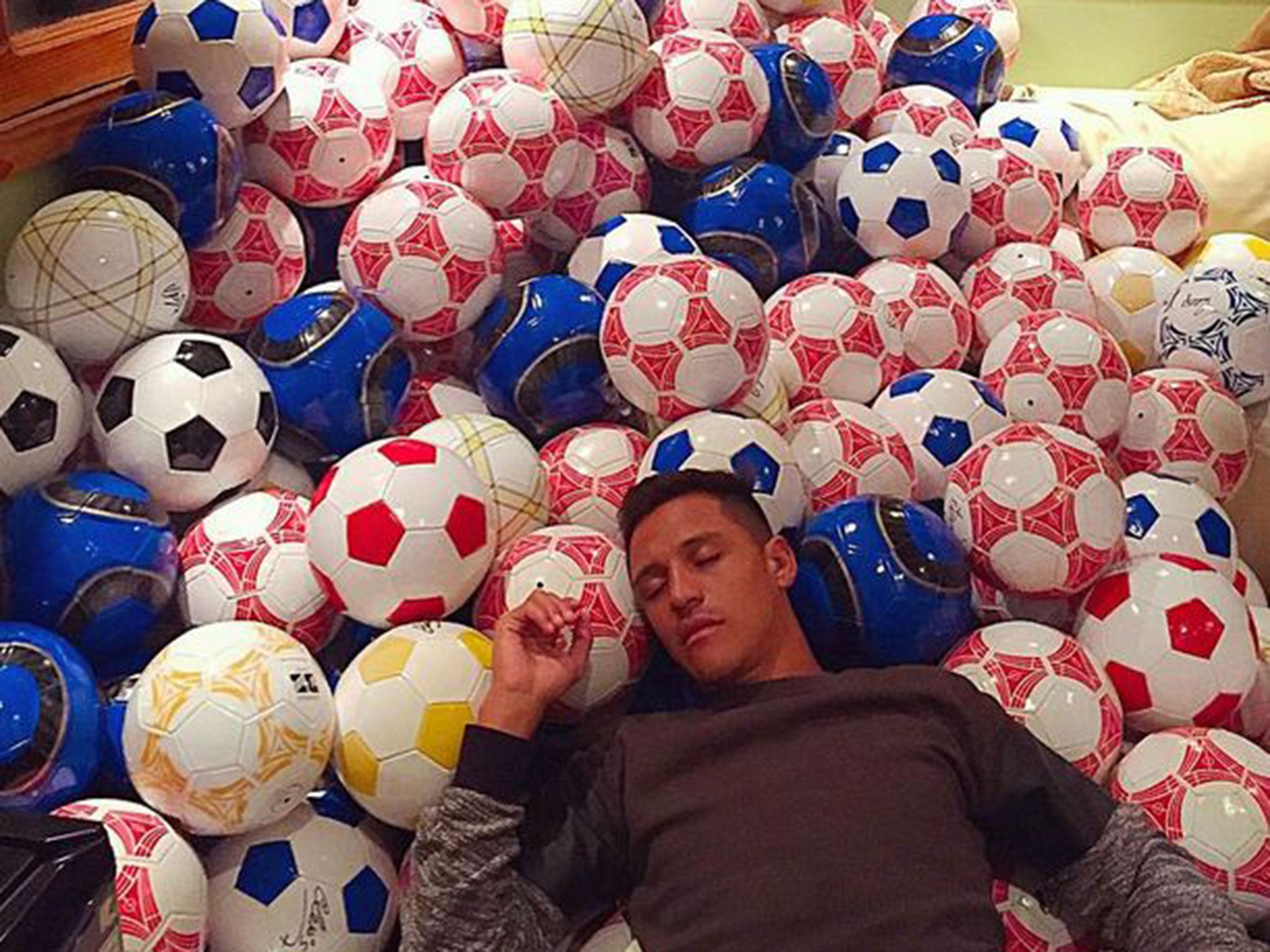 Alexis Sanchez sleeping on the signed footballs