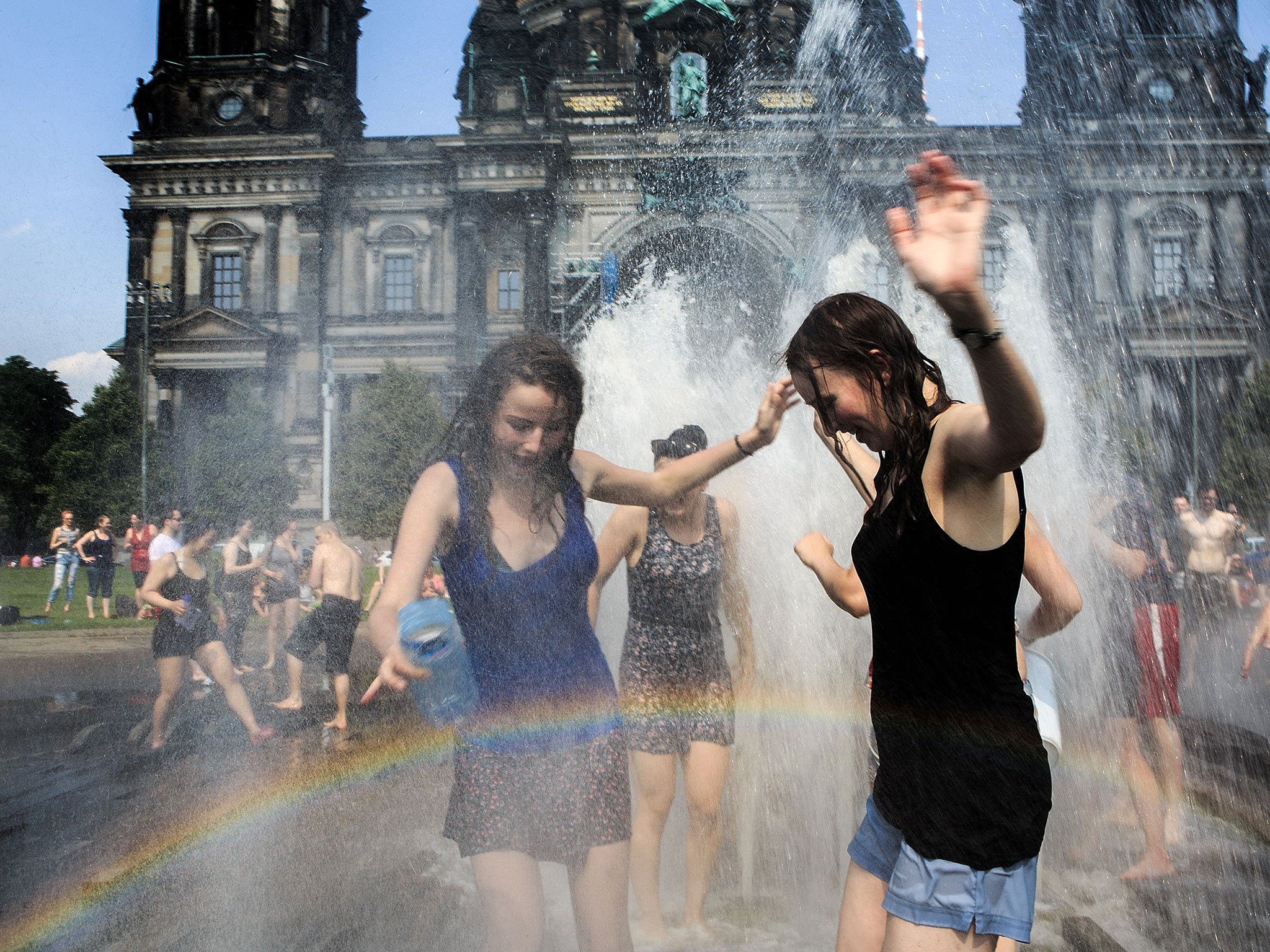People enjoy the water fountain in the landmark Lustgarten in Berlin earlier this summer