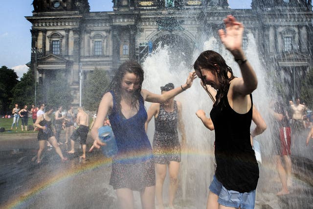 People enjoy the water fountain in the landmark Lustgarten in Berlin earlier this summer