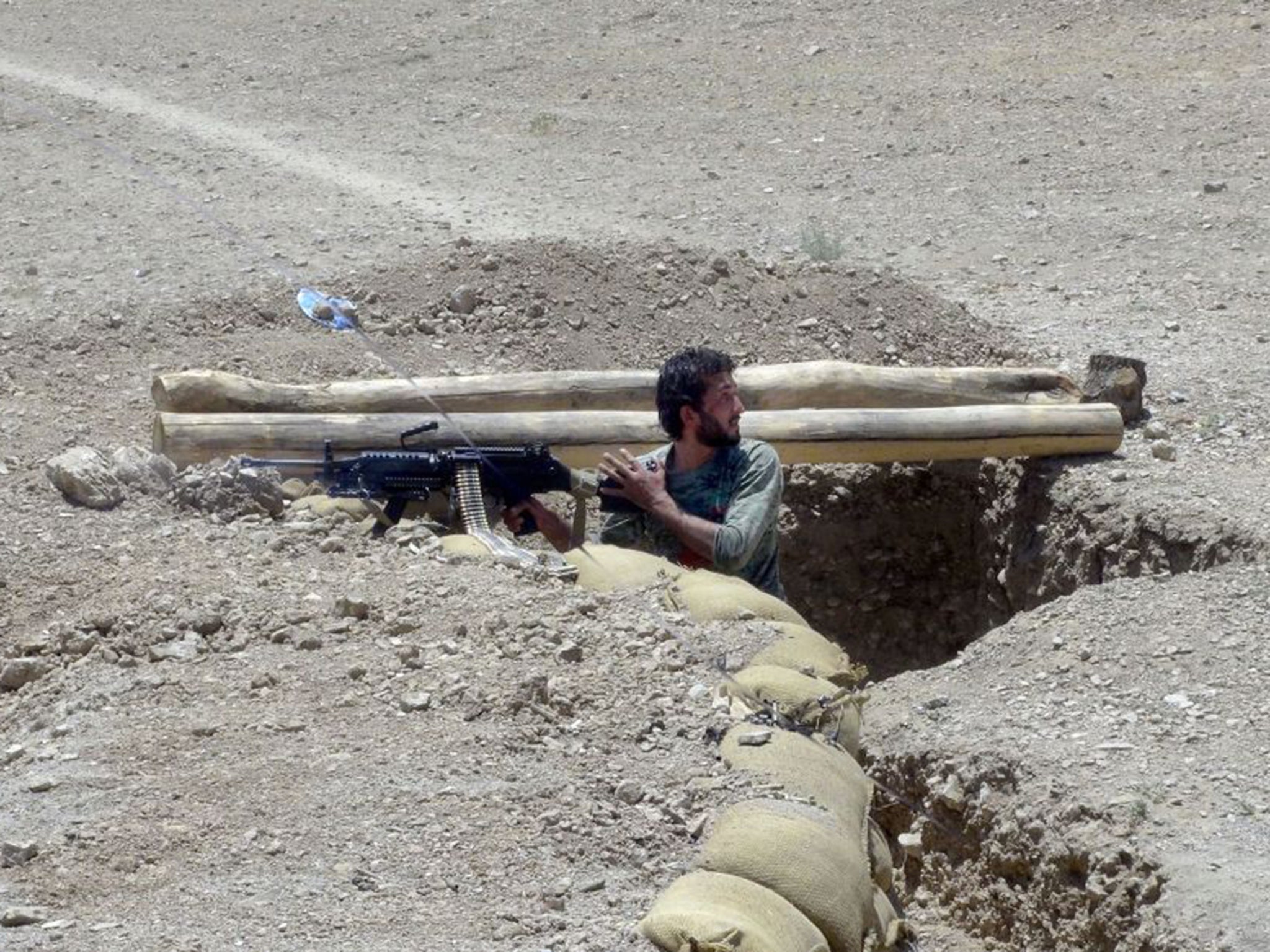 An Afghanistan National Army soldier standing guard in a trench in the district of Baraki Barak, east of Kabul